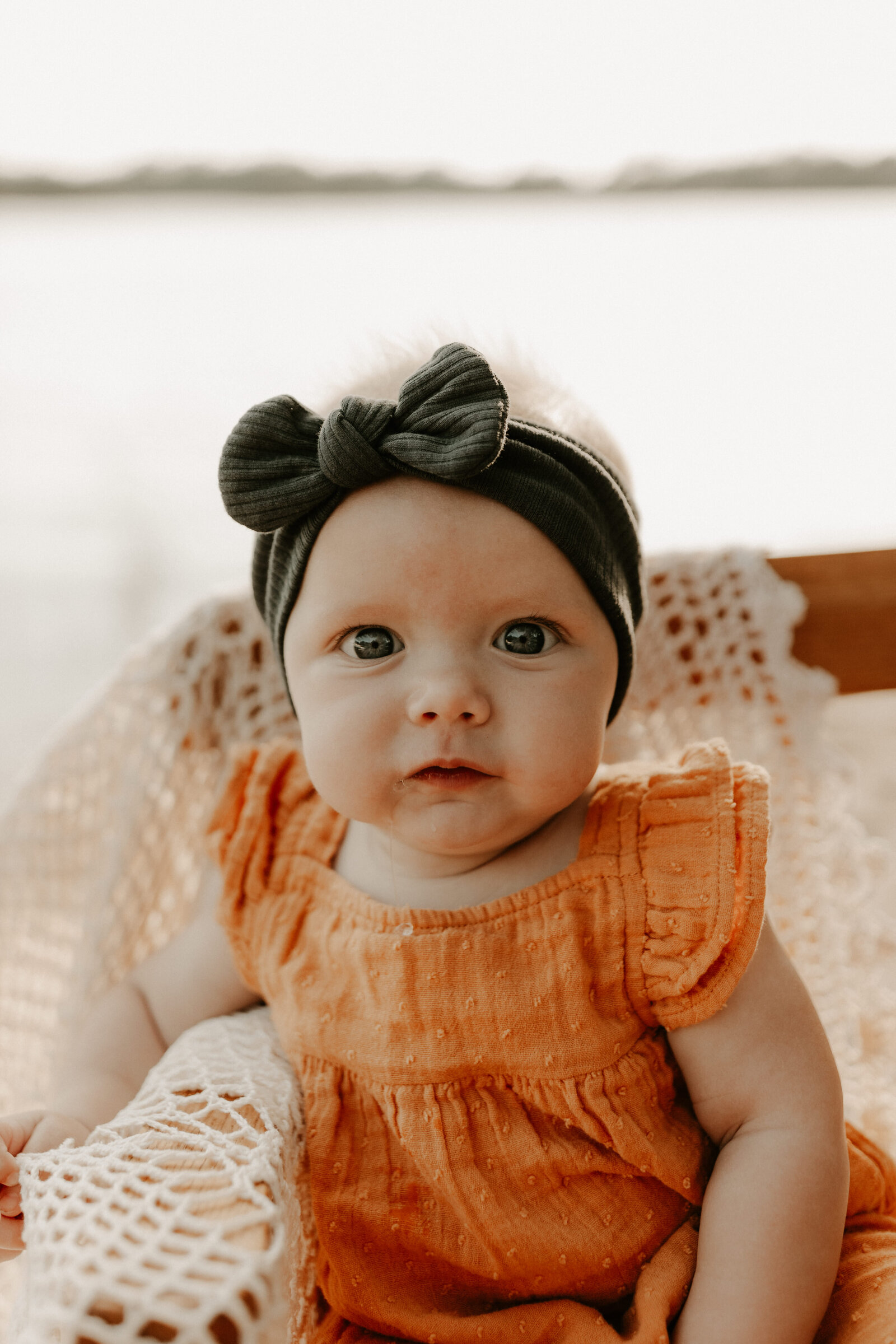 close up of 6 month old girl smiling at camera on northwoods beach in Wisconsin