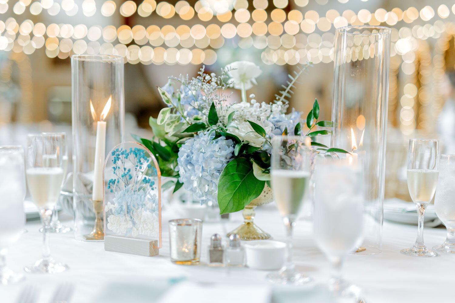 Romantic wedding table centerpiece with blue hydrangeas and candles