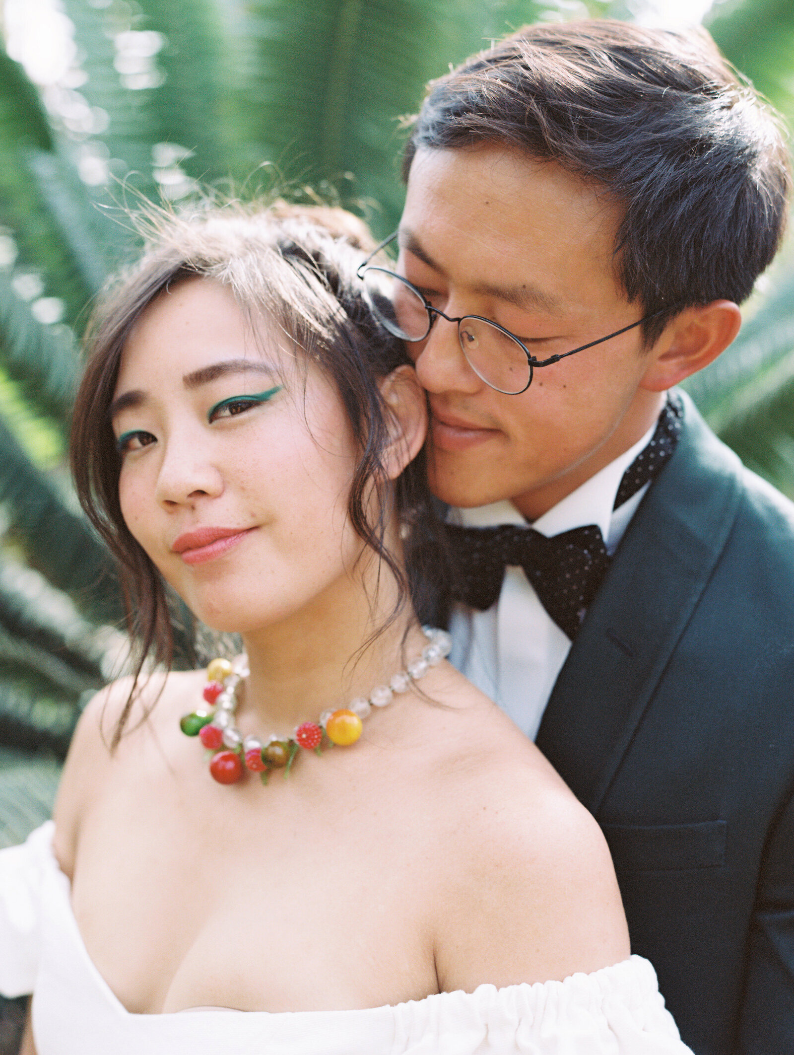 An intimate portrait of the bride and groom, as the bride smiles at the camera and the groom behind her, by California photographer Megan Lynn, My Sun and Stars Co.