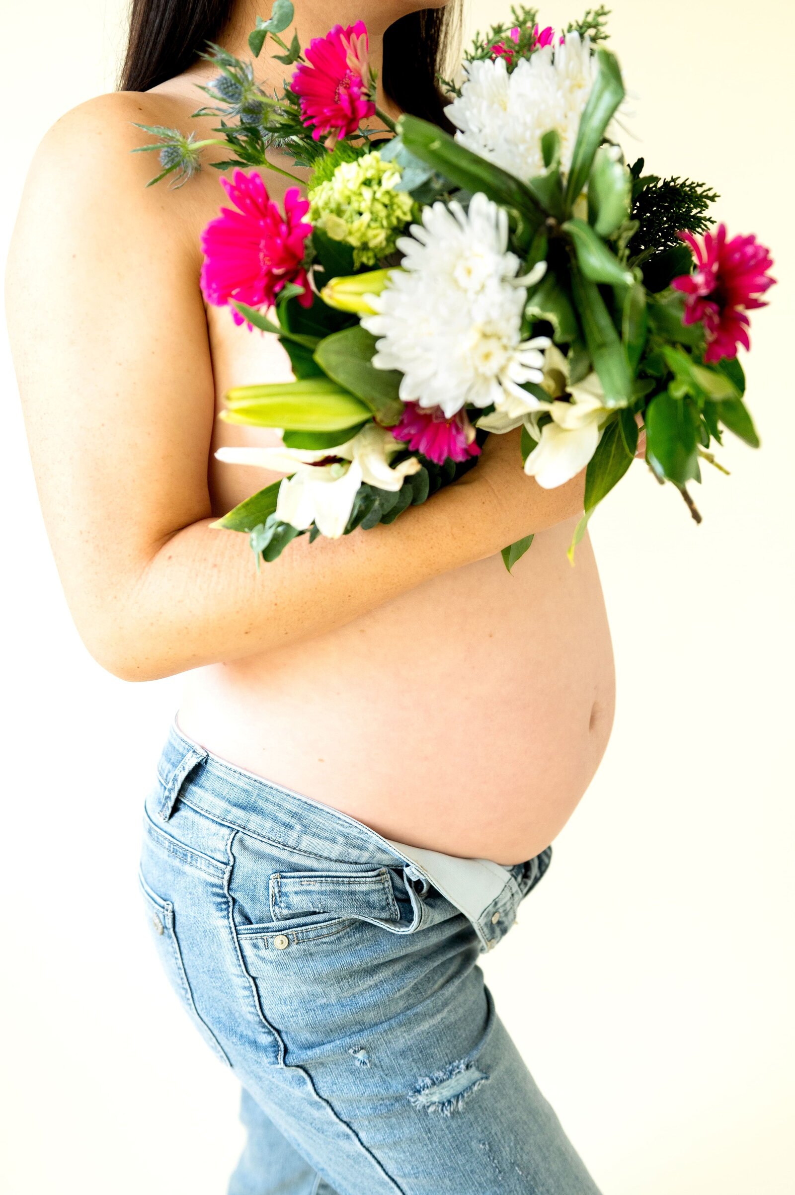 pregnant woman holding flowers to her belly