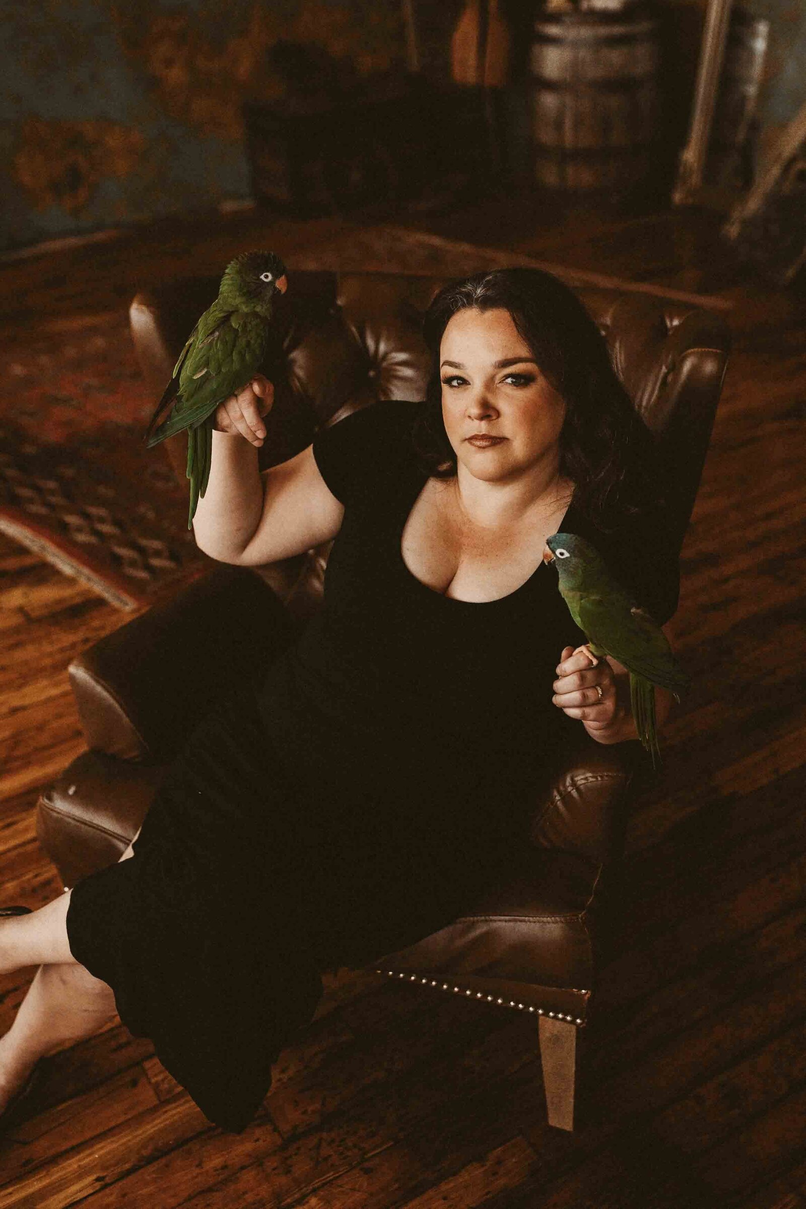 woman in a black dress holding her two birds