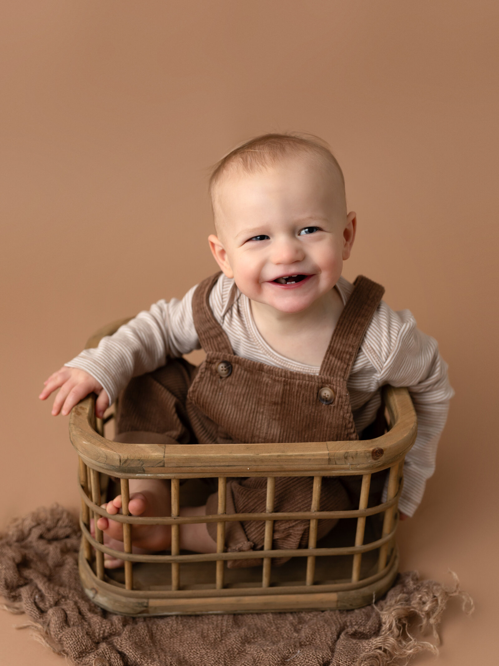 baby boy posed in basket for studio portrait clevleand cake smash photographer