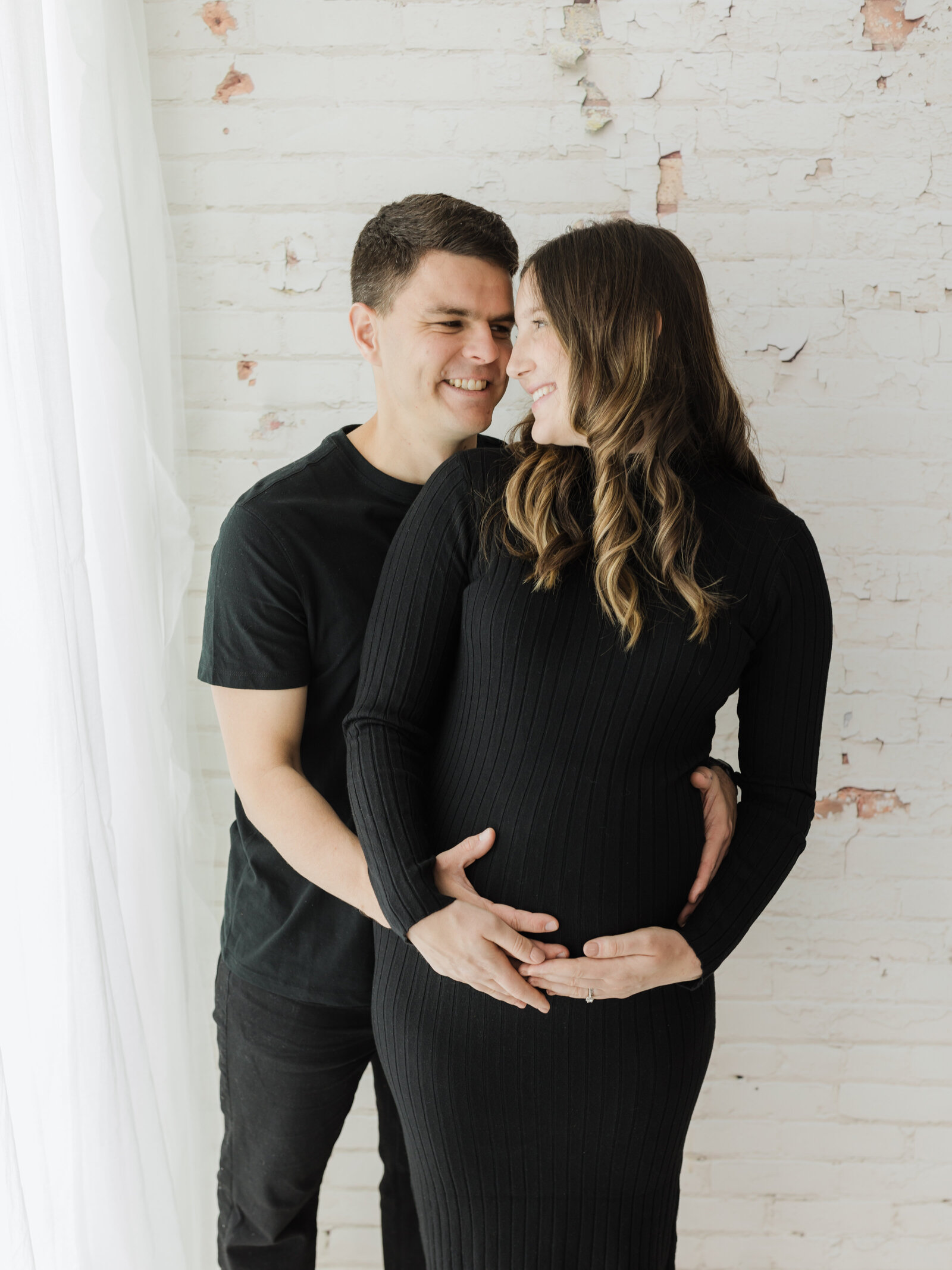 husband and pregnant wife holding baby bump for maternity photoshoot cleveland maternity photographer