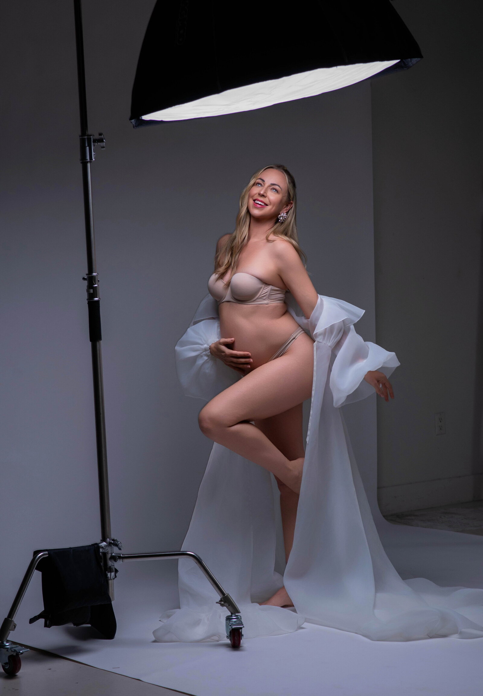 Expecting Mom happy with parts of lighting equipment in the image.