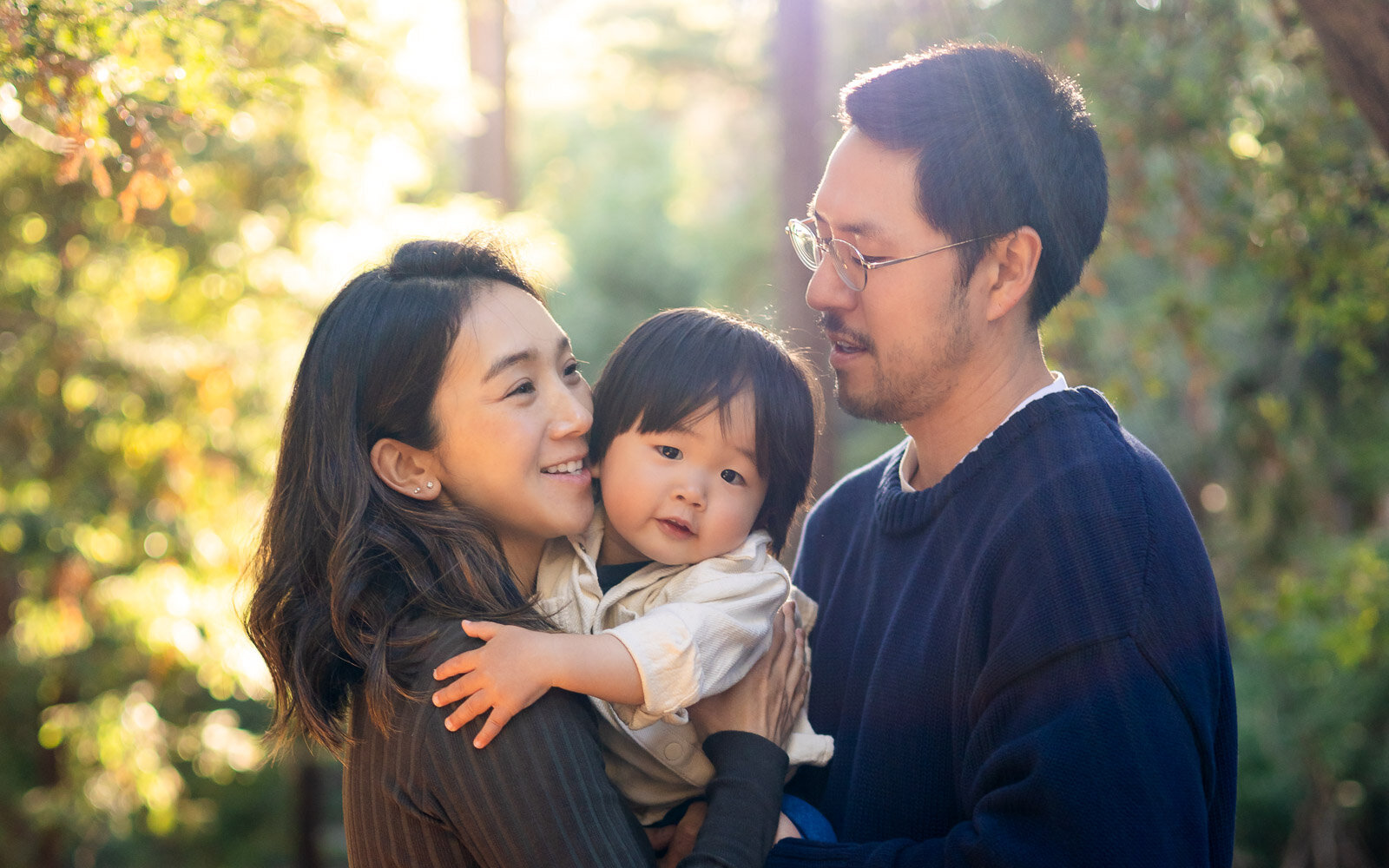 Parents hugging child during nature family photo shoot – Ellobelle Photography Family Photographer