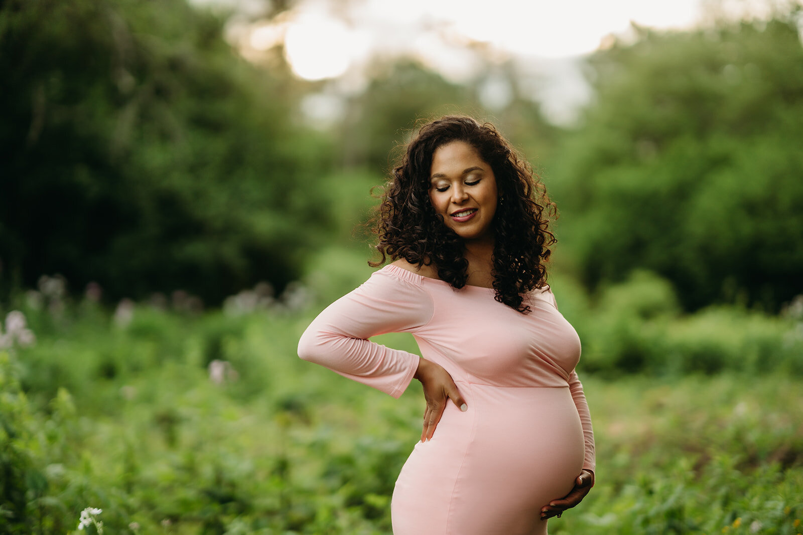 pregnant woman in pink dress at springtime