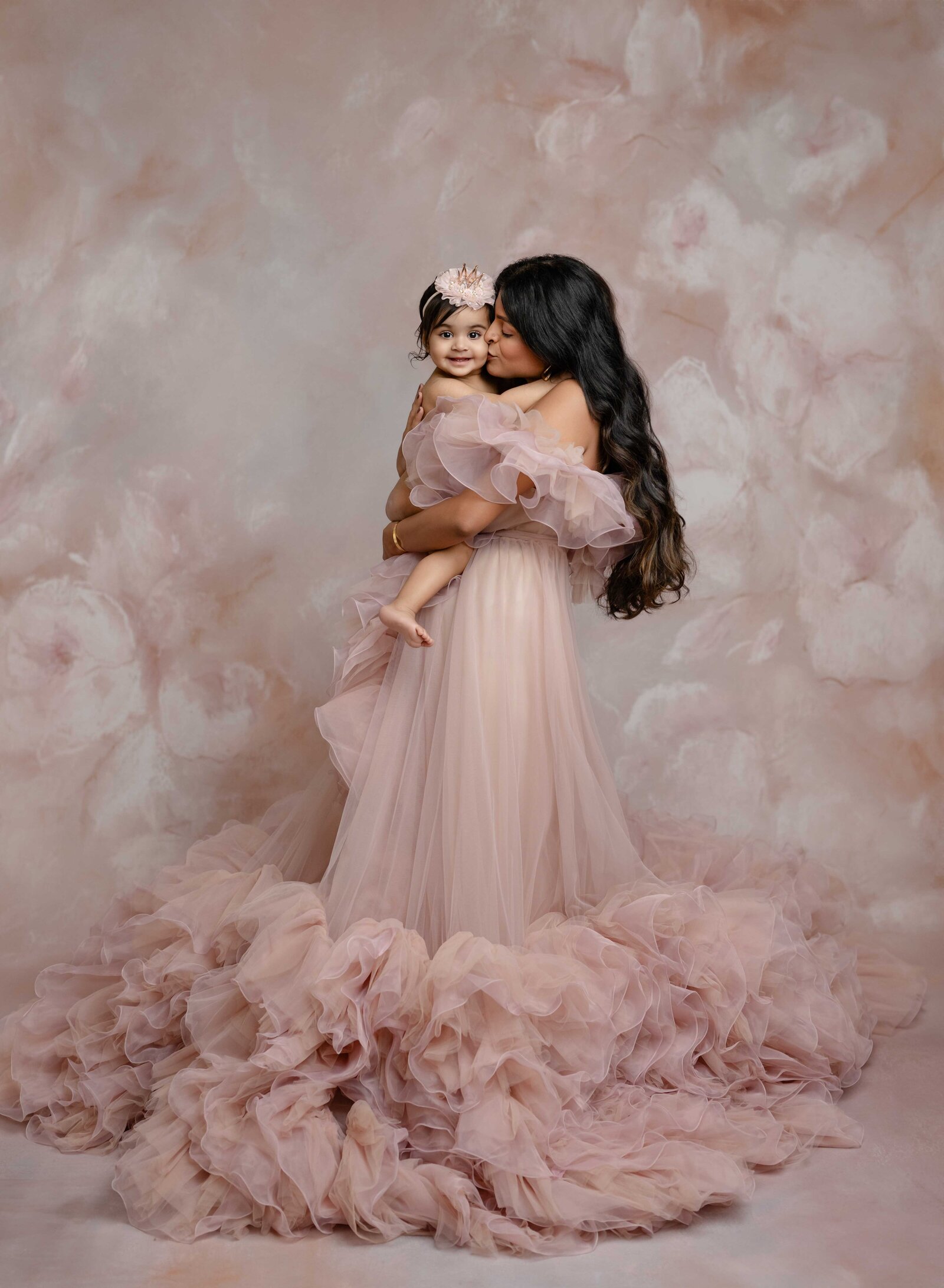 Mom in pink gown kissing baby girl. 1Mommy and me photo taken by Jenni Nikki Photography in Atlanta, GA.