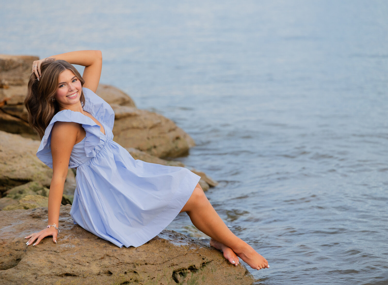 seniorgirl on rocks by the water