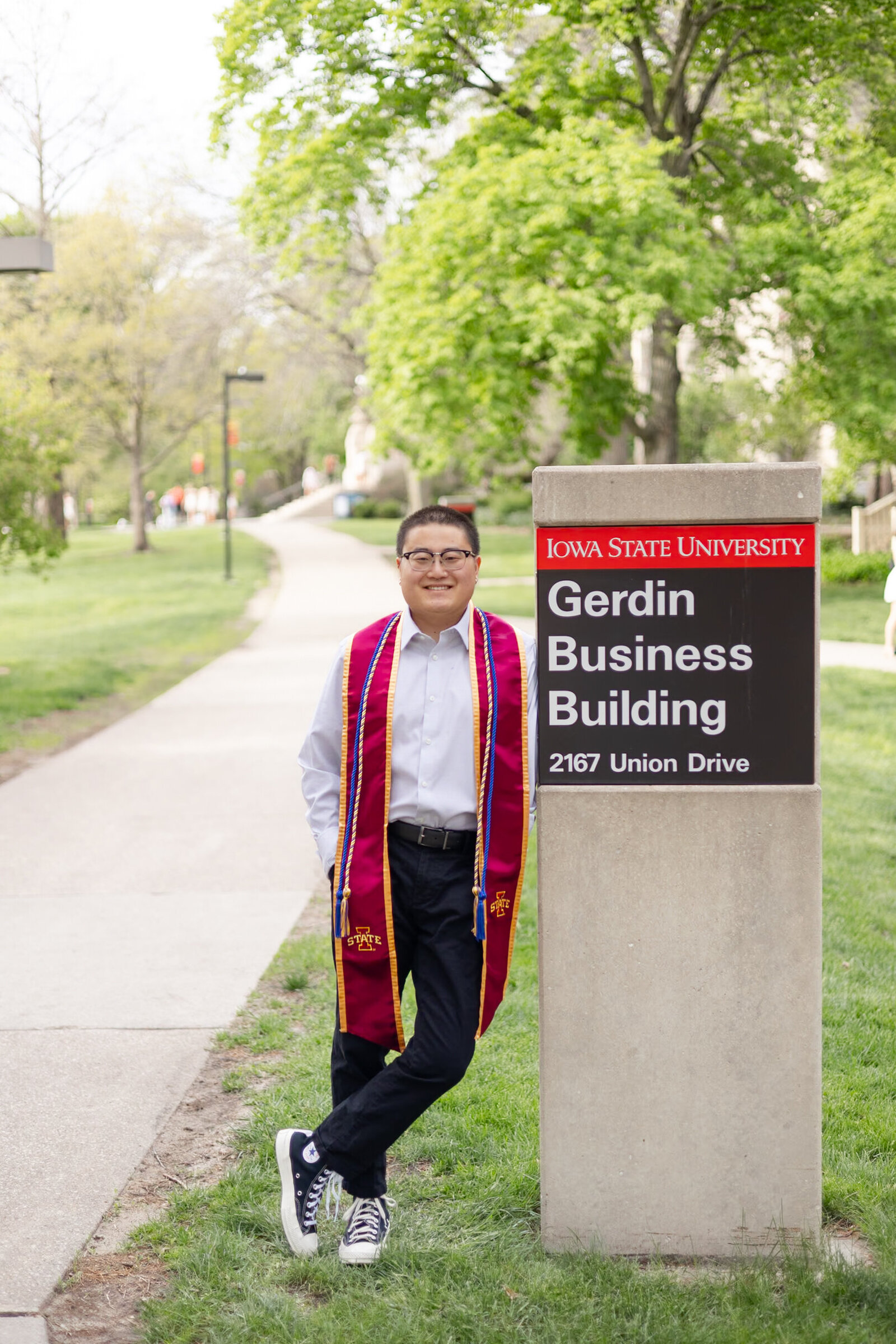 young man poses for college graduation photo at Gerdin Business Building