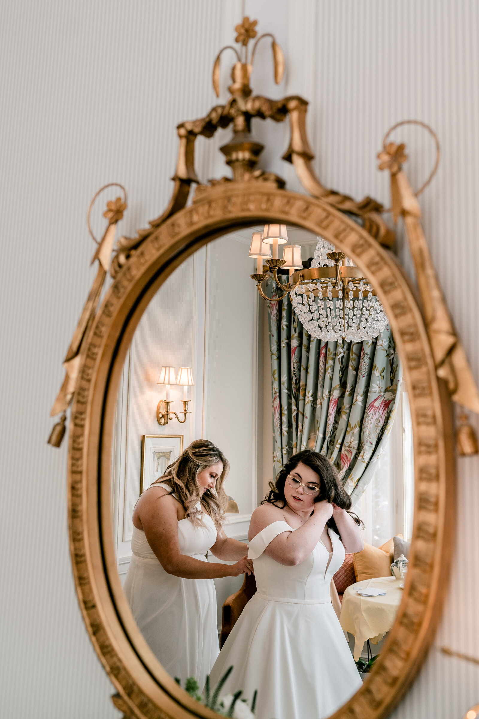 A bride getting ready with the help of her bridesmaid before a wedding at The Inn at Little Washington in Virginia