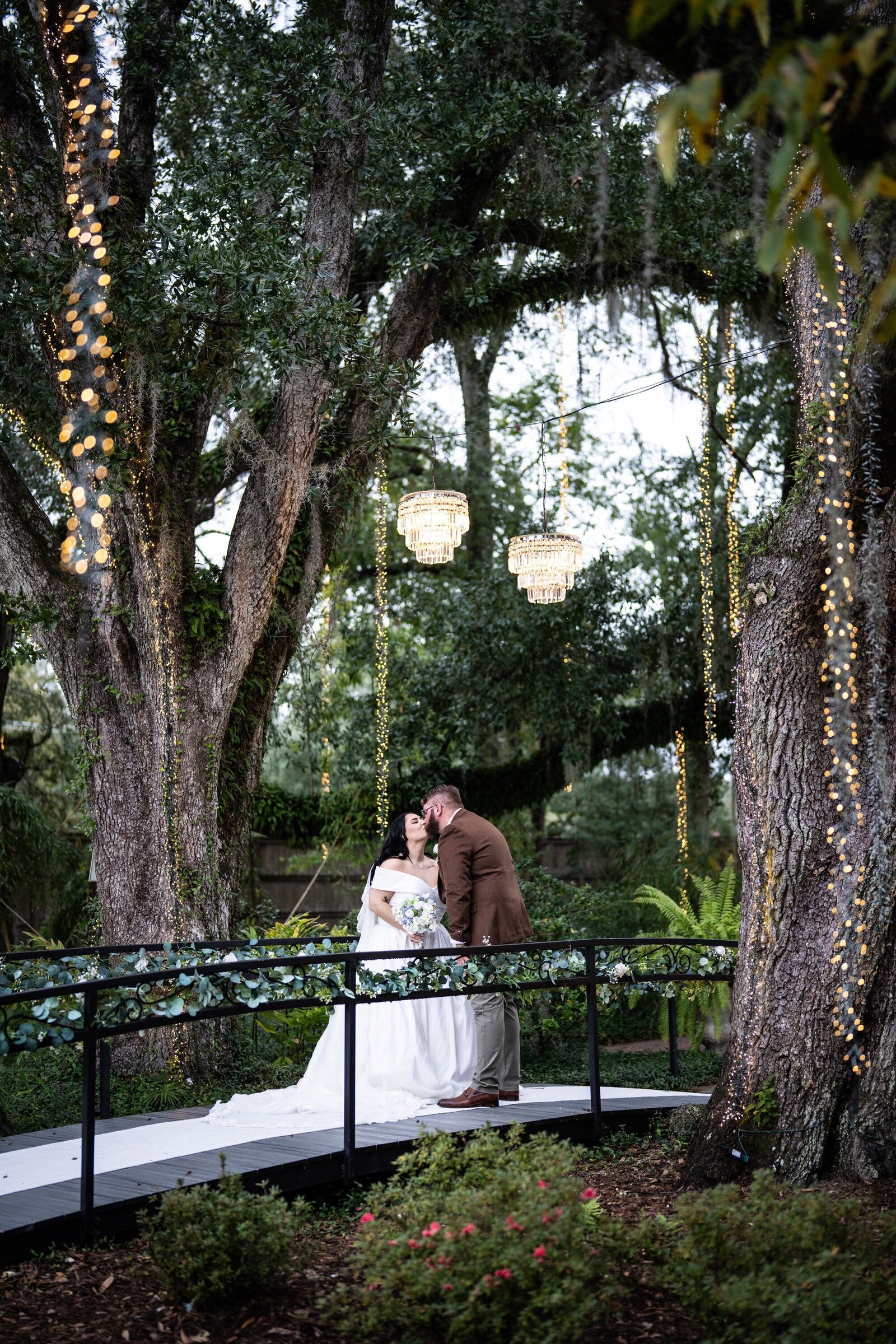 Bride and groom on bridge surrounded by trees at The Oaks wedding in Pontchatoula