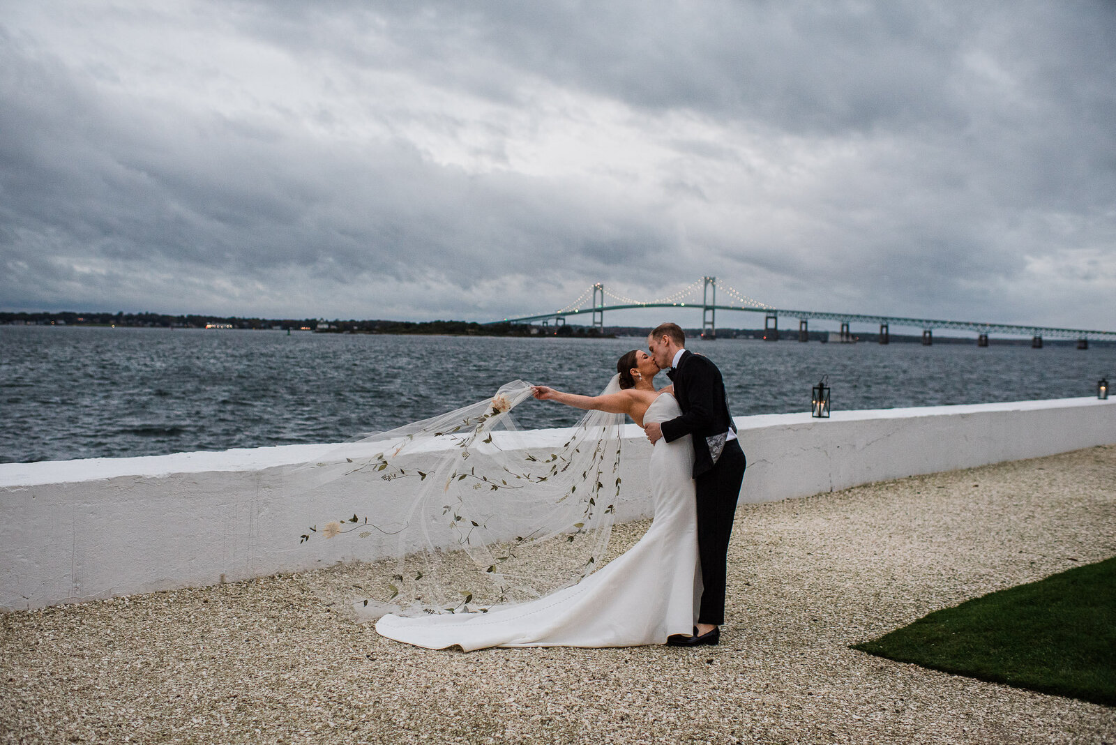 bride and groom kiss in front of Newport Bridge