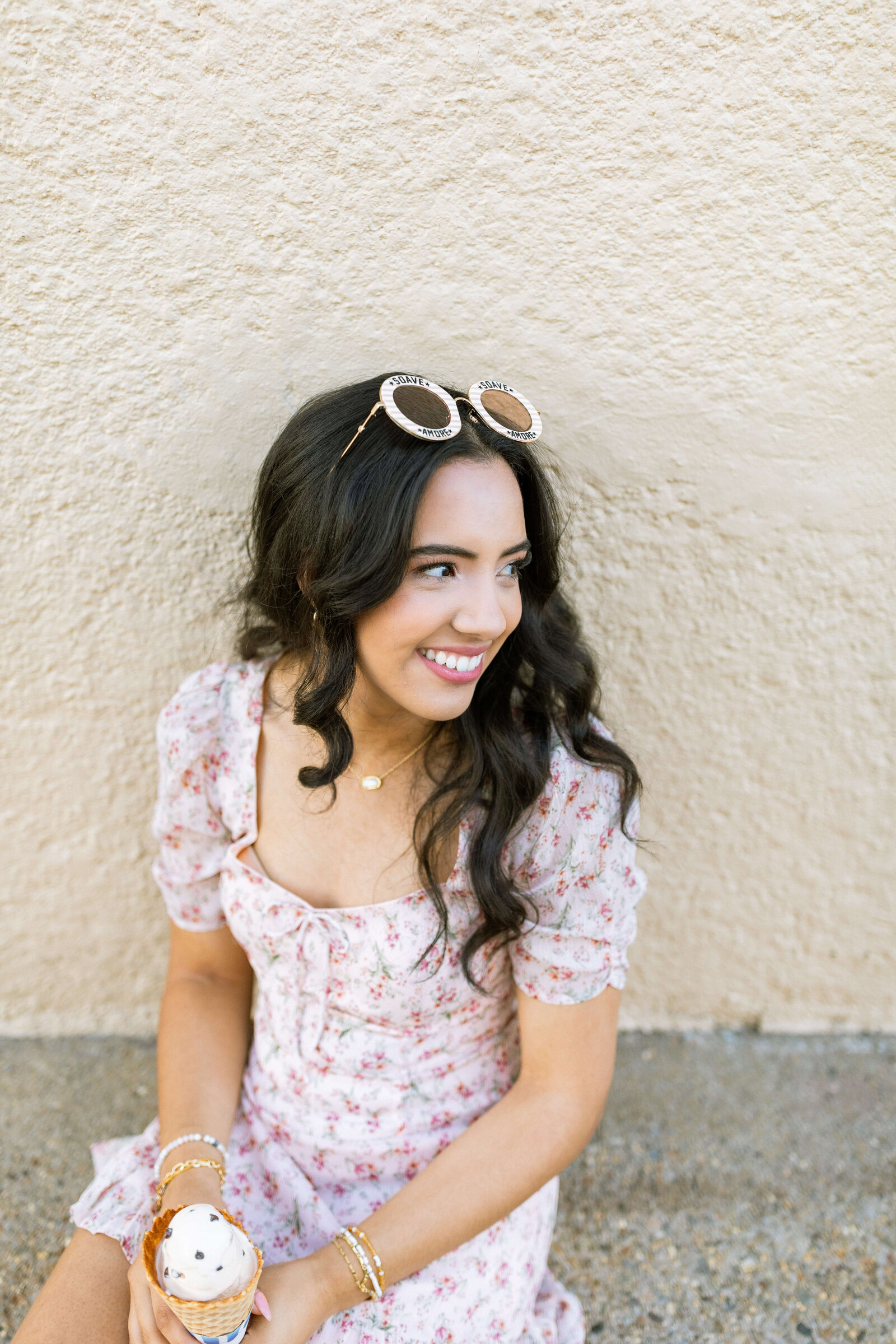 dark haired girl wearing floral dress, holding ice cream cone, and glasses