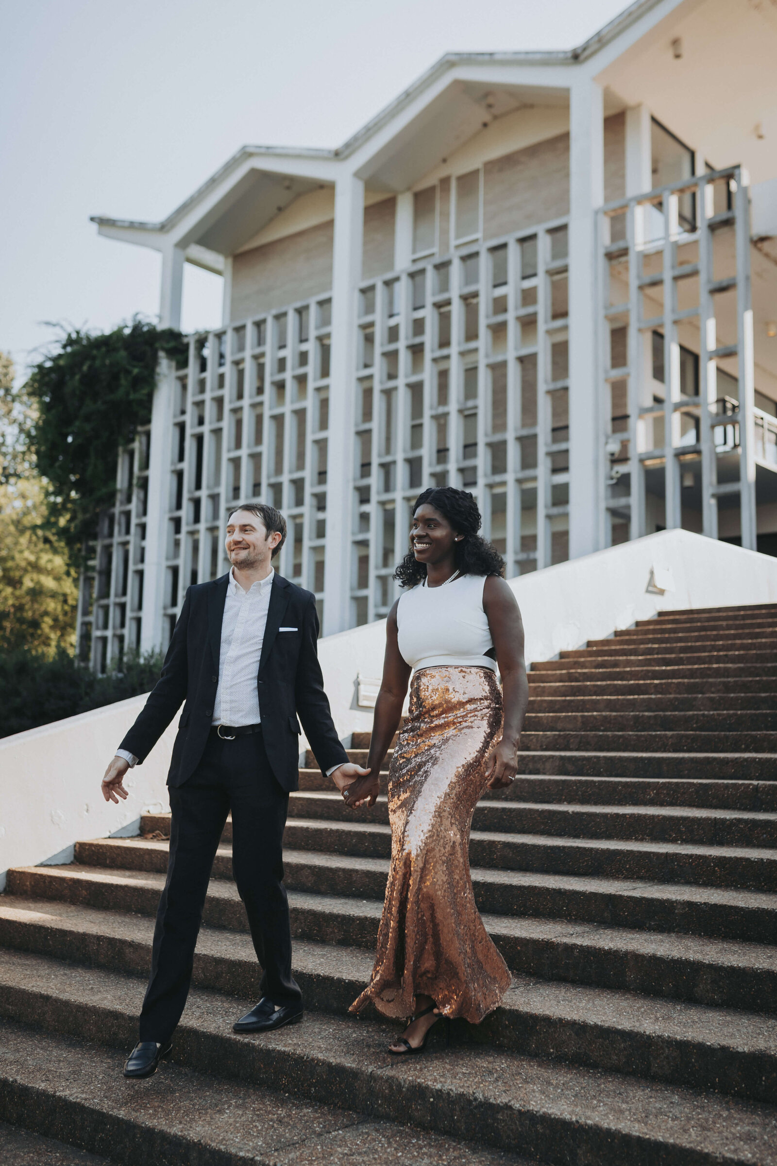 Couple walks together on the steps of the Art Institute in Overton Park.