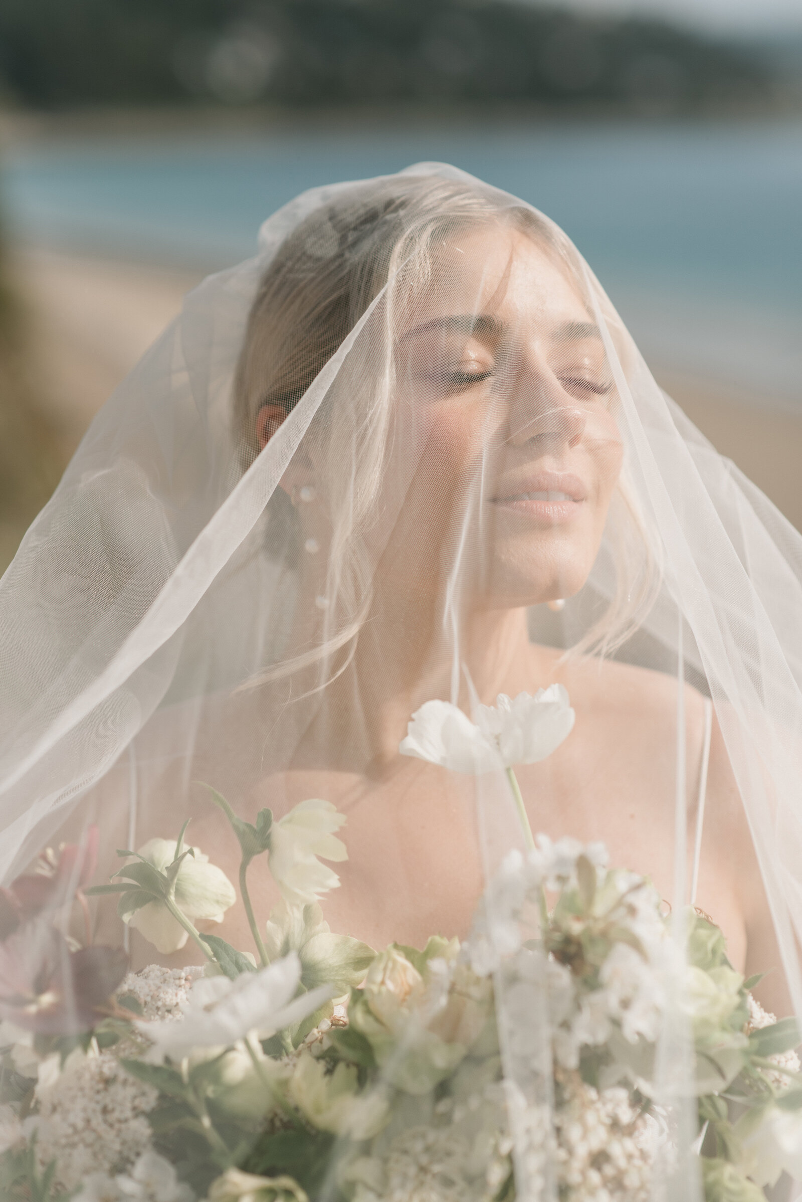 bridal portrait of bride under her veil with her florals