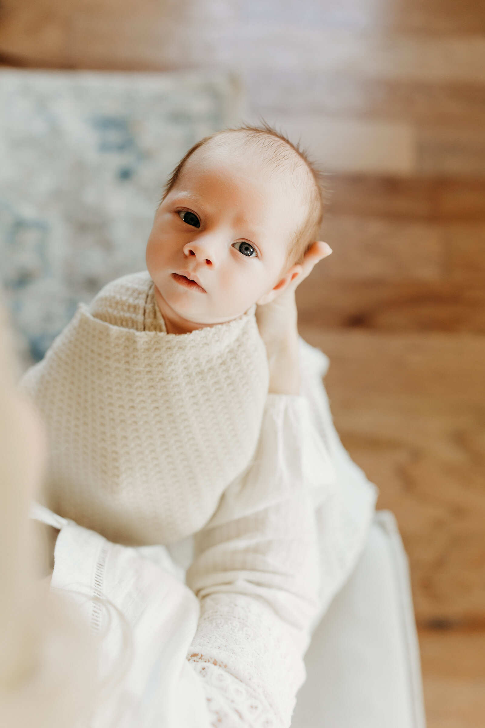 wrapped baby looks around during lifestyle newborn session near Birmingham