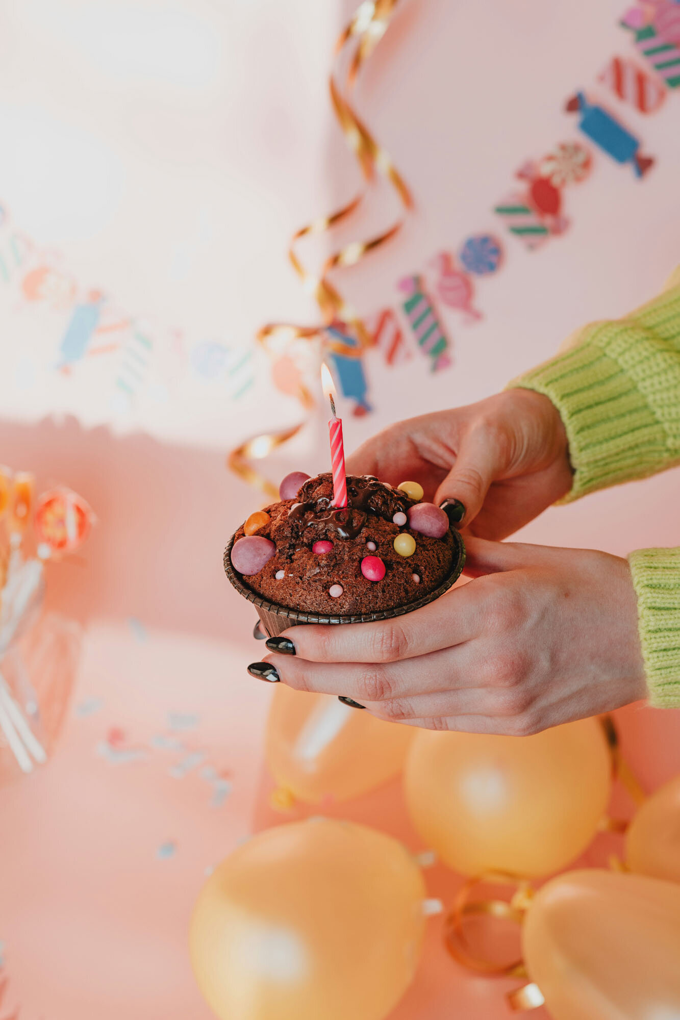Person is holding a cupcake with a candle in it