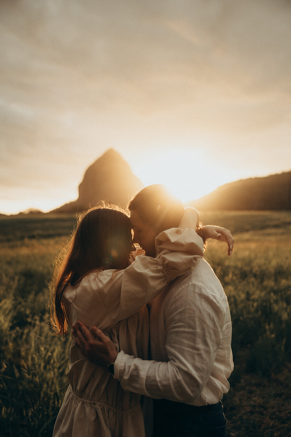 Sunshine coast couples photographer capturing a warm moment of intimacy between boyfriend and girlfriend with sunset in background