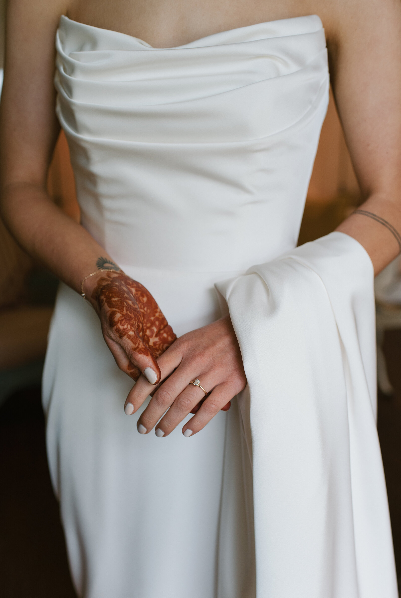 bride holding her dress with henna on her hands