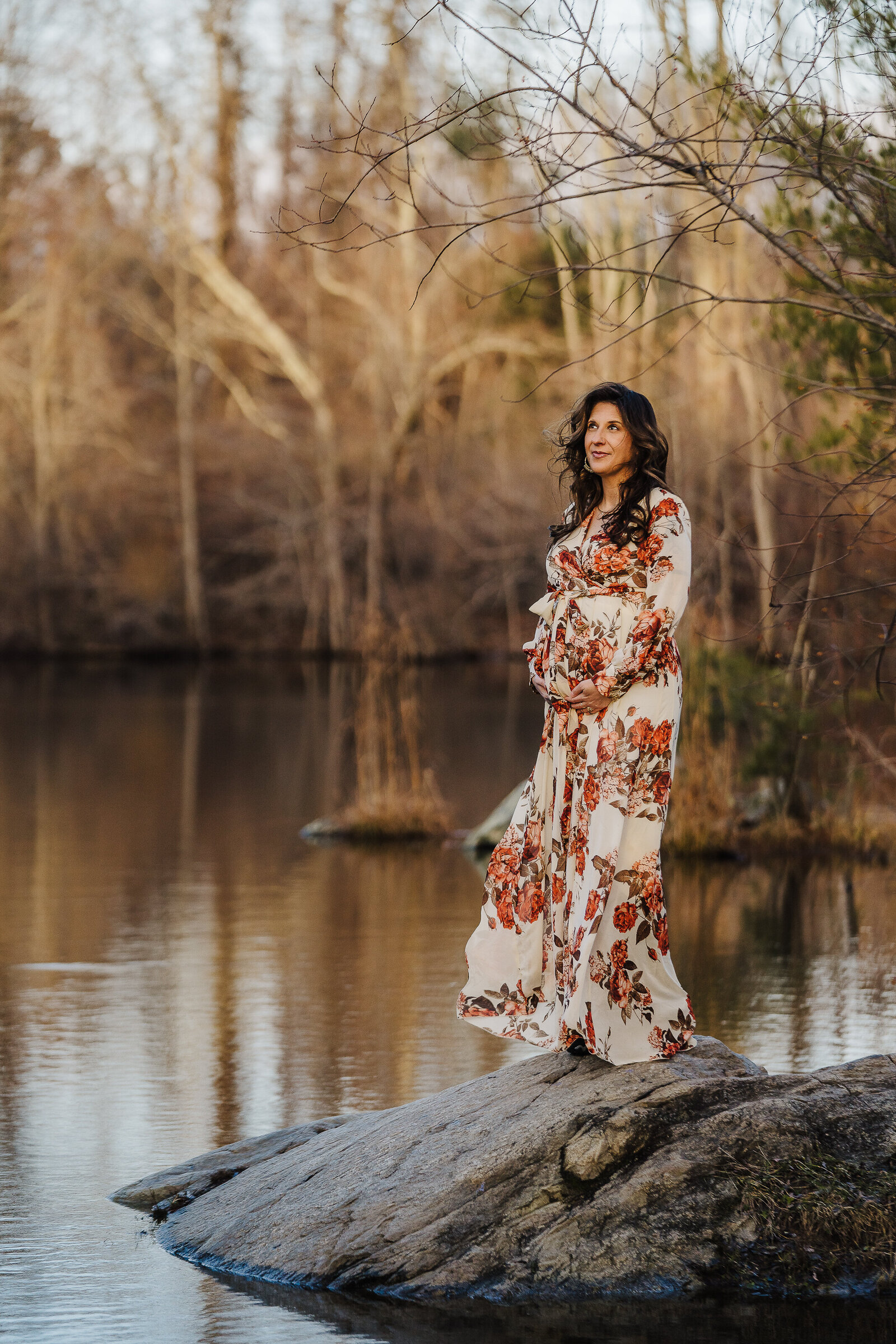 pregnant woman on rock in lake