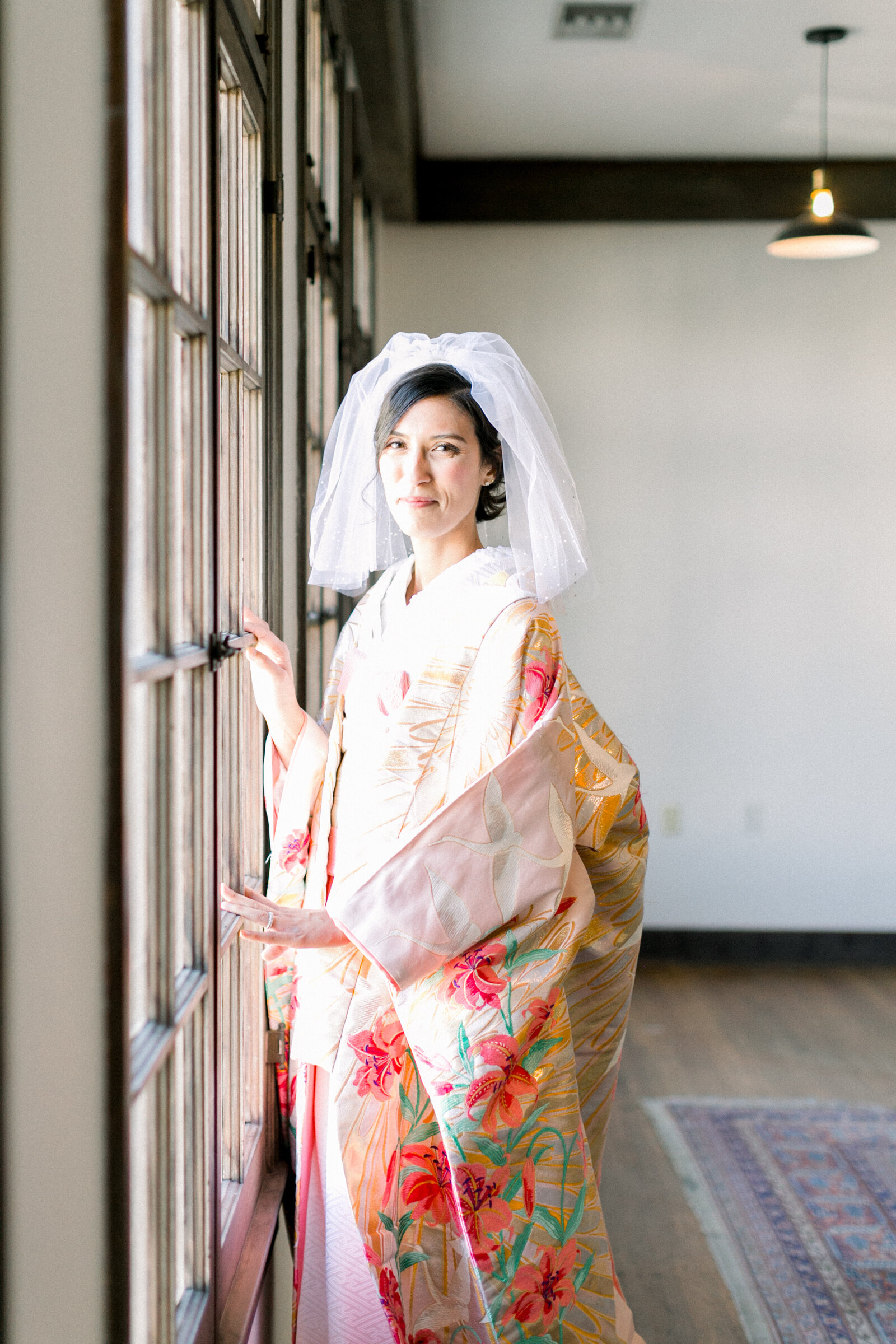 Elegant bridal portrait by the window in colorful uchikake at The Ebell Club Long Beach, kimono rental Los Angeles wedding photography | ロサンゼルスThe Ebell Club Long Beachで色鮮やかな打掛を纏い窓辺で微笑む花嫁、着物レンタルウェディングフォト