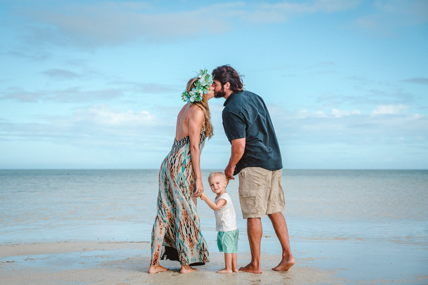 family on beach kissing