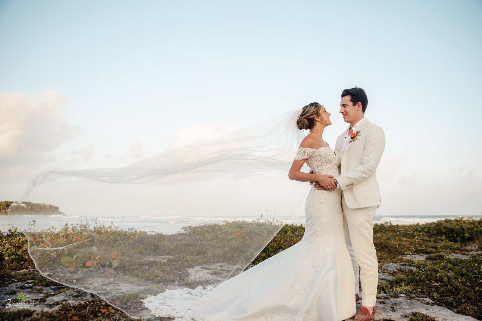 bride and groom standing on a beach at their destination wedding