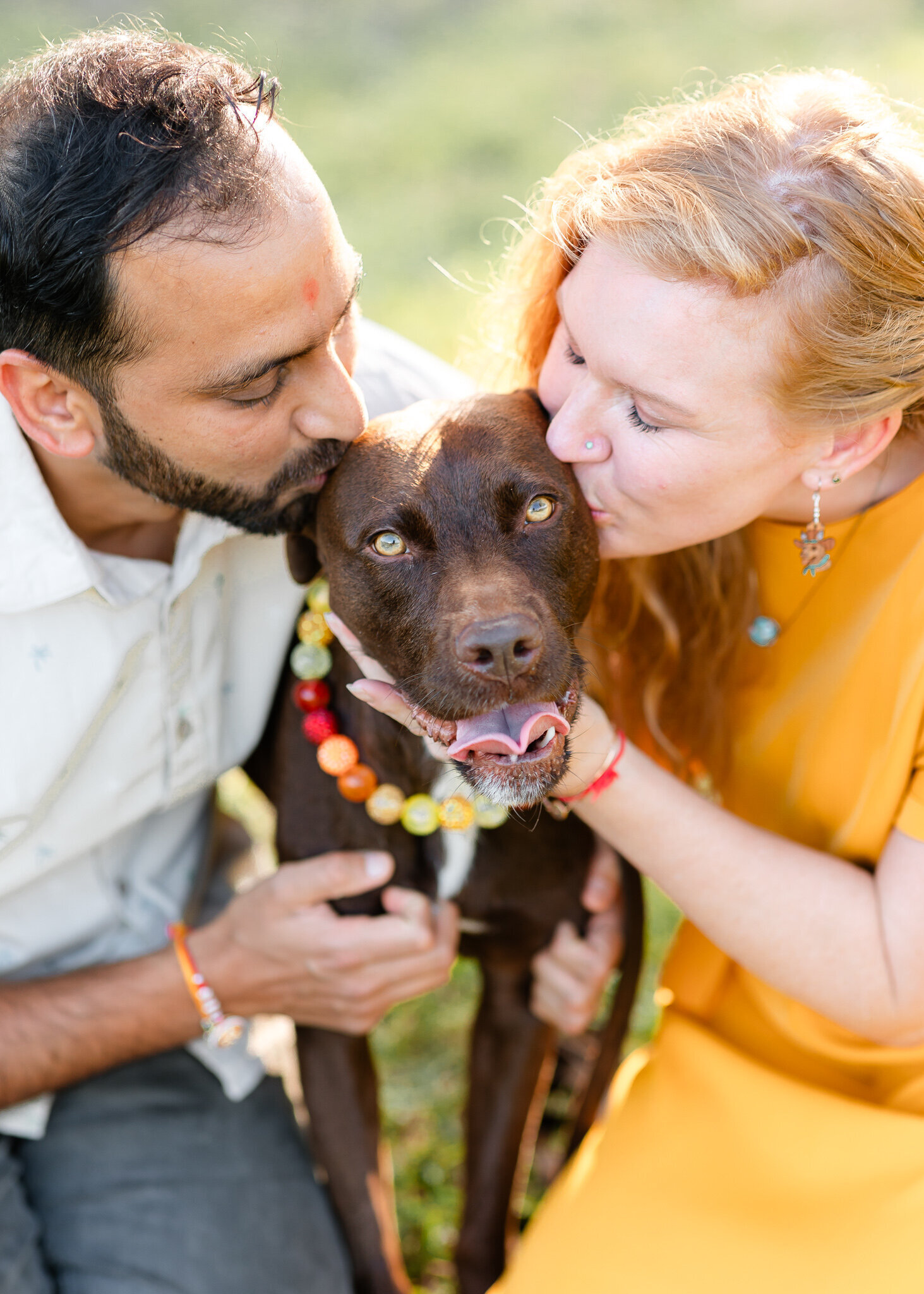 Mom and dad kissing dog