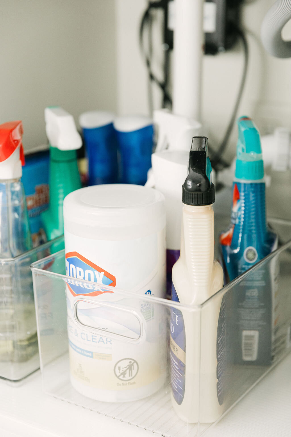 Clear plastic organizing bins from Container Store for cleaning supplies