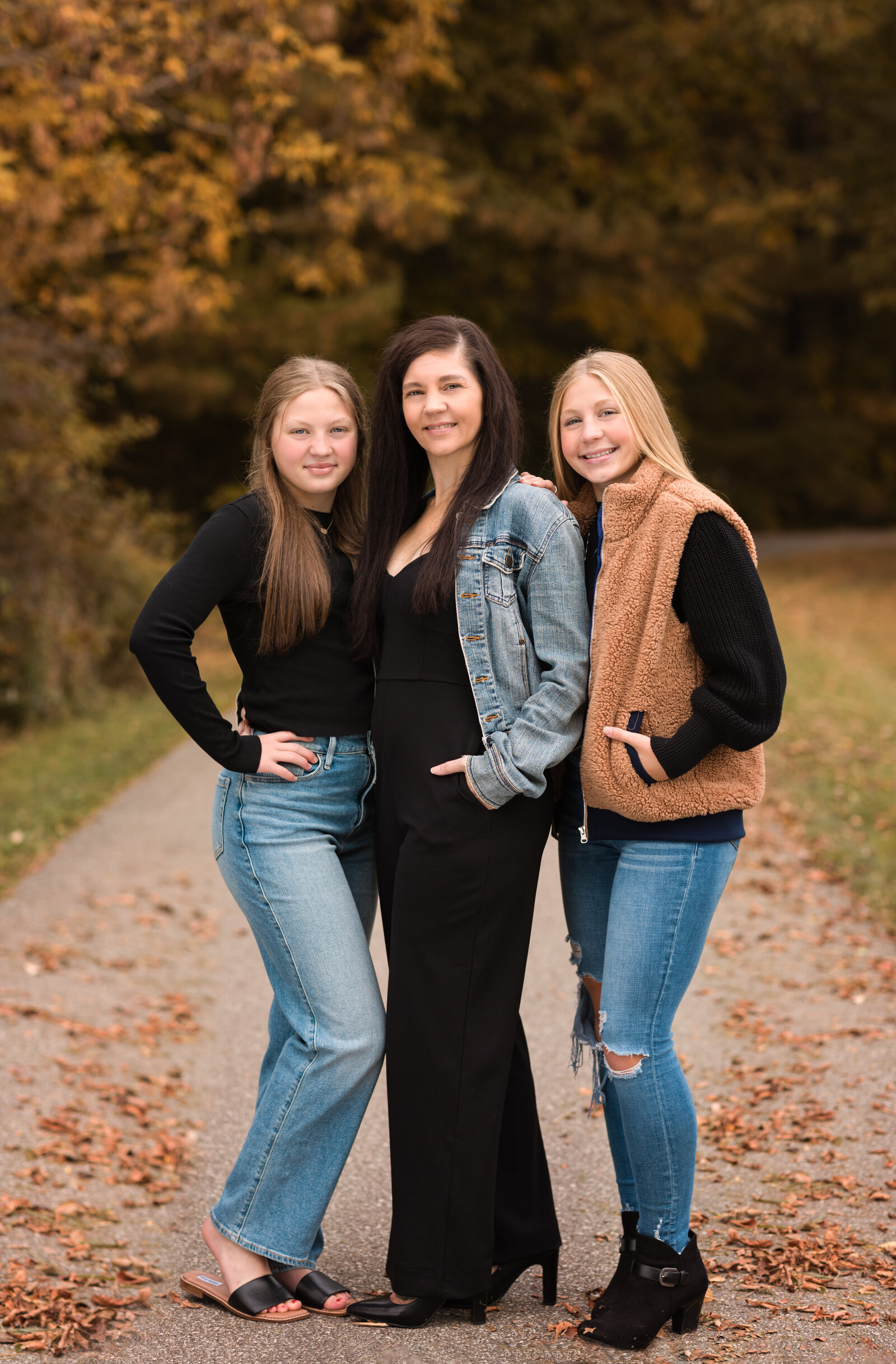 mom and two daughters posing for fall family portraits