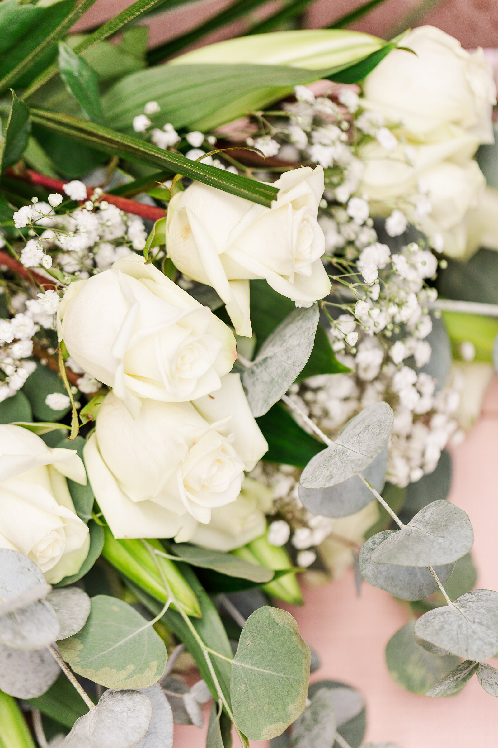 Lush bridal bouquet featuring white roses, eucalyptus, and delicate florals at an Arrowhead Lodge wedding, creating an elegant and timeless look