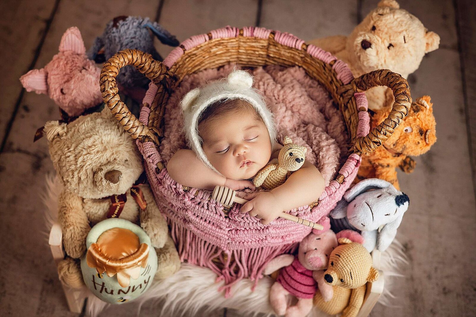A peaceful baby sleeps in a basket, surrounded by soft teddy bears, captured by Bia Schaefer Photography, Orlando’s top newborn photographer.