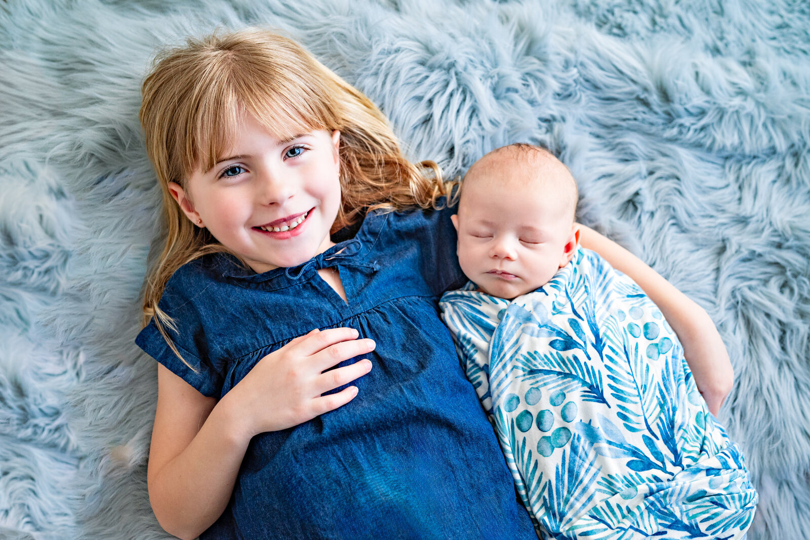 A  big sister cradling her baby  brother  during a photo session at the studio in Huntsville  Alabama