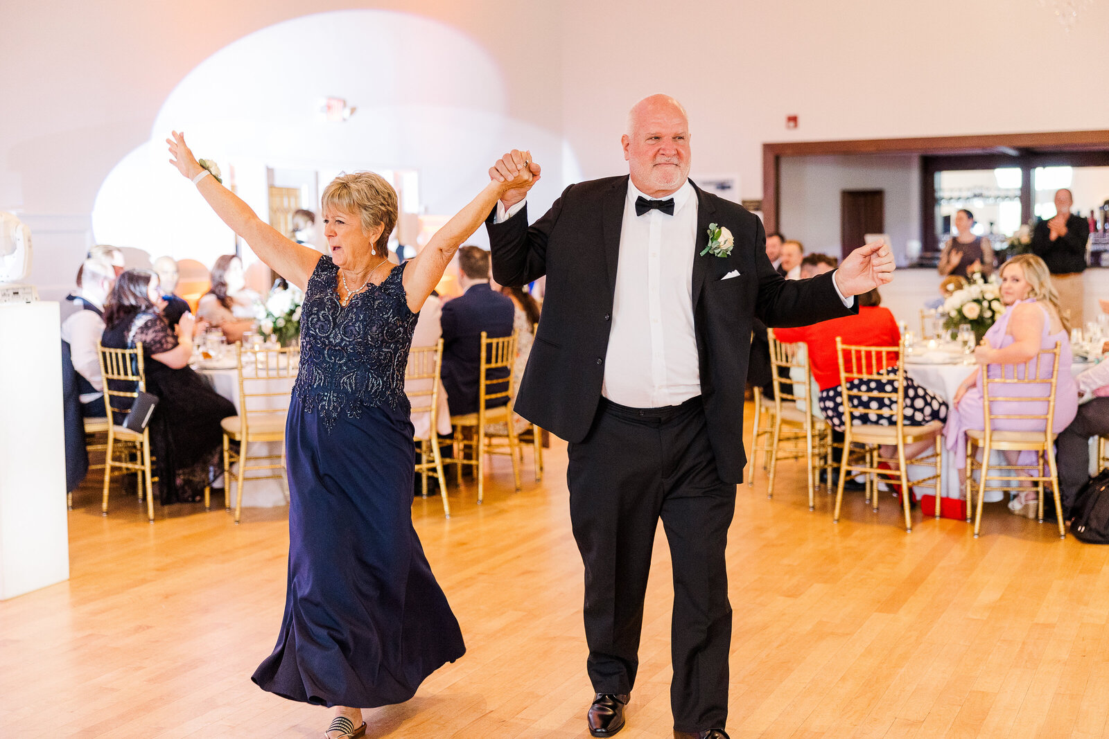 Father and mother of the bride entering the reception with smiles at SkyView Golf Club