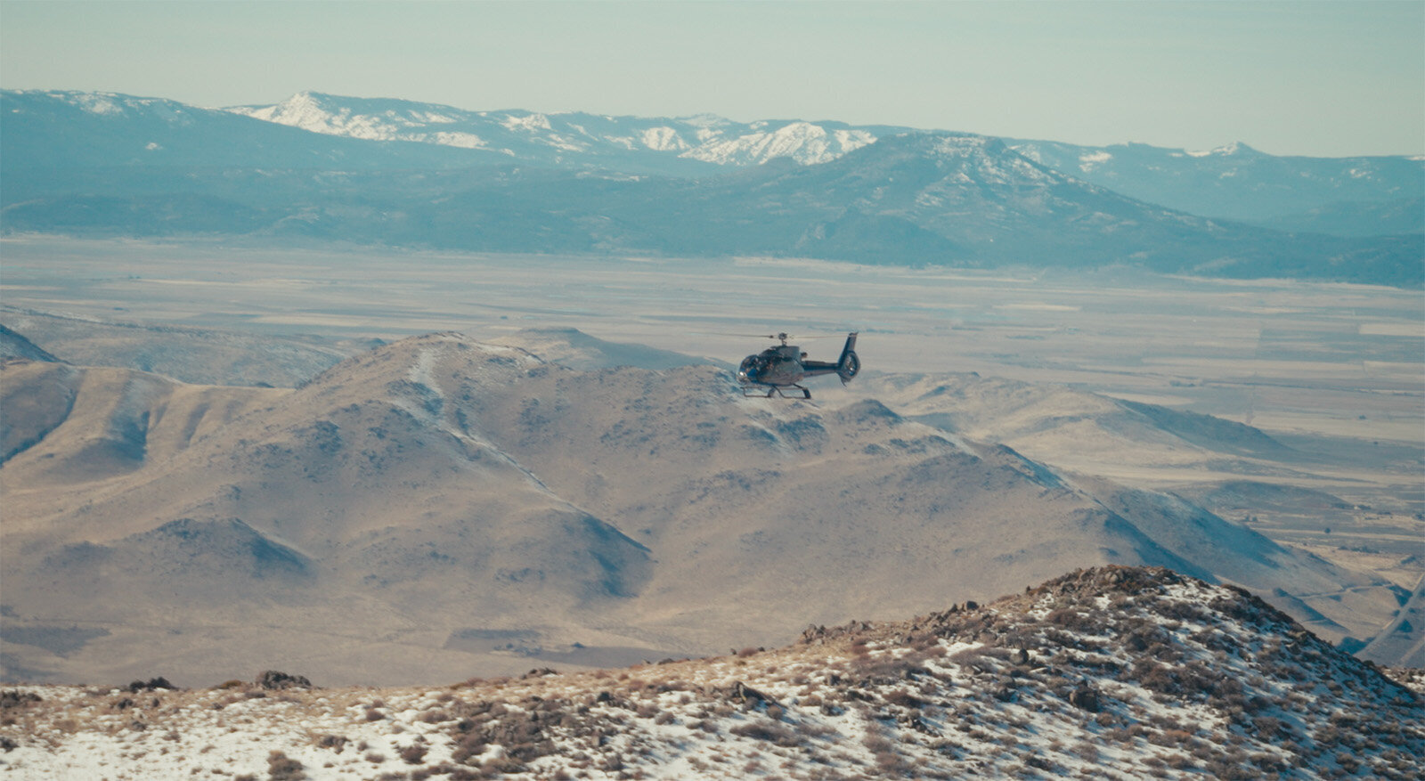 Airbus ec130 helicopter flying over mountain ranges in Nevada Reno