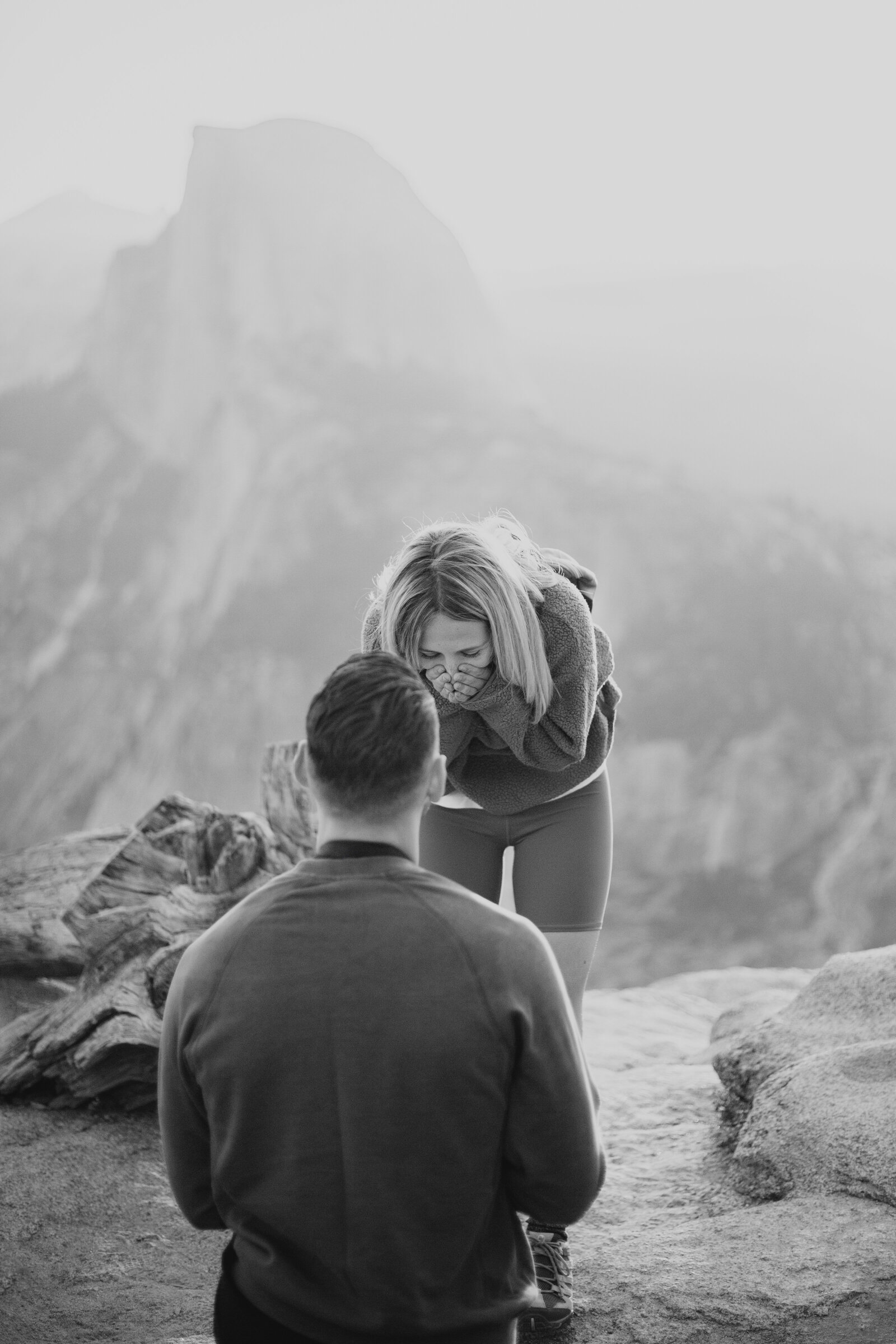 A wedding proposal between two hikers at sunrise in front of Half Dome in Yosemite National Park.