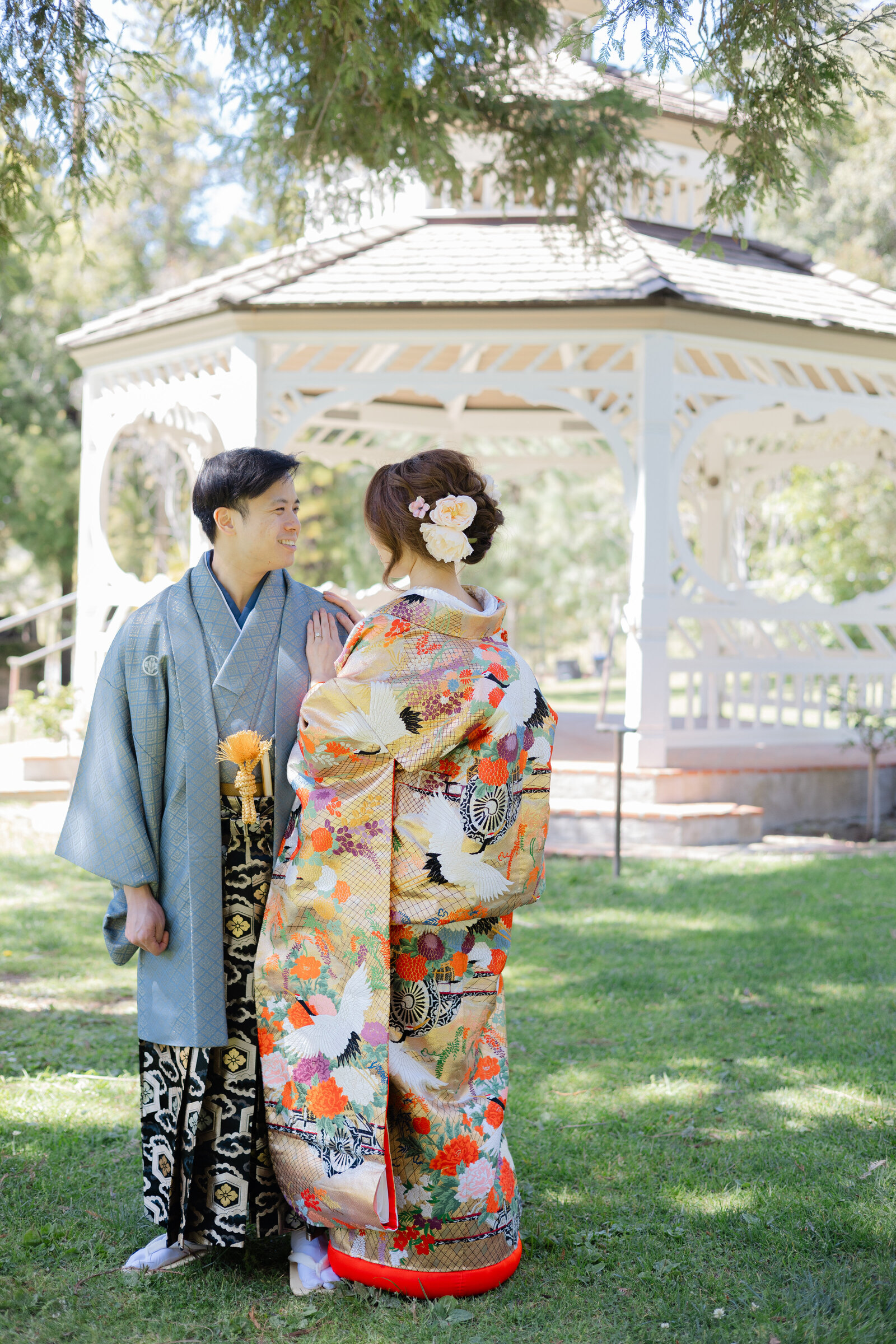 Bride in gold floral uchikake and groom in montsuki at gazebo of Doctor’s House Museum, Los Angeles California. Beautiful wedding kimono rental photoshoot | ドクターズハウス博物館のガゼボで金色花柄色打掛の花嫁と紋付袴の新郎。ロサンゼルス カリフォルニアの着物レンタル。