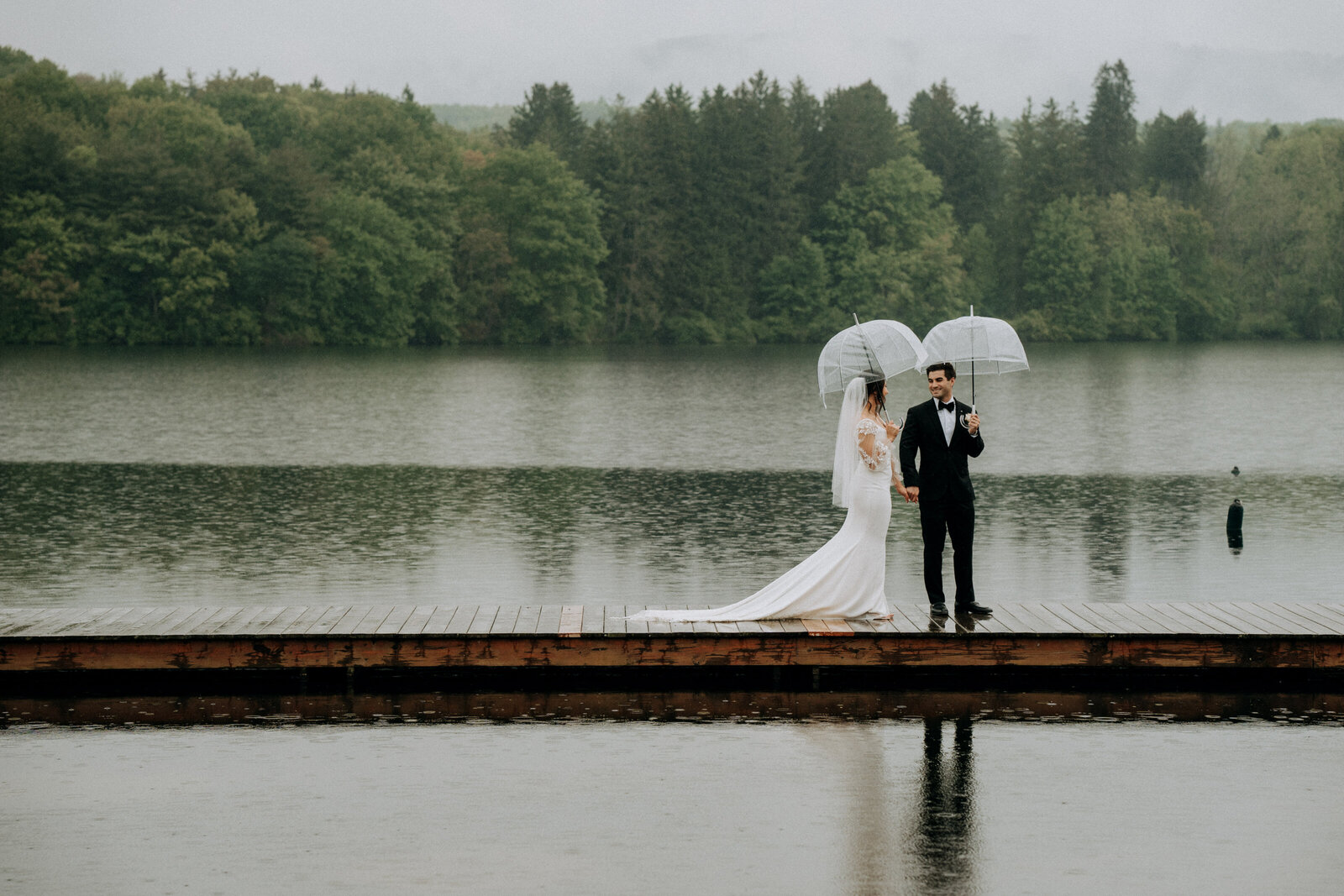 bride and groom holding umbrellas