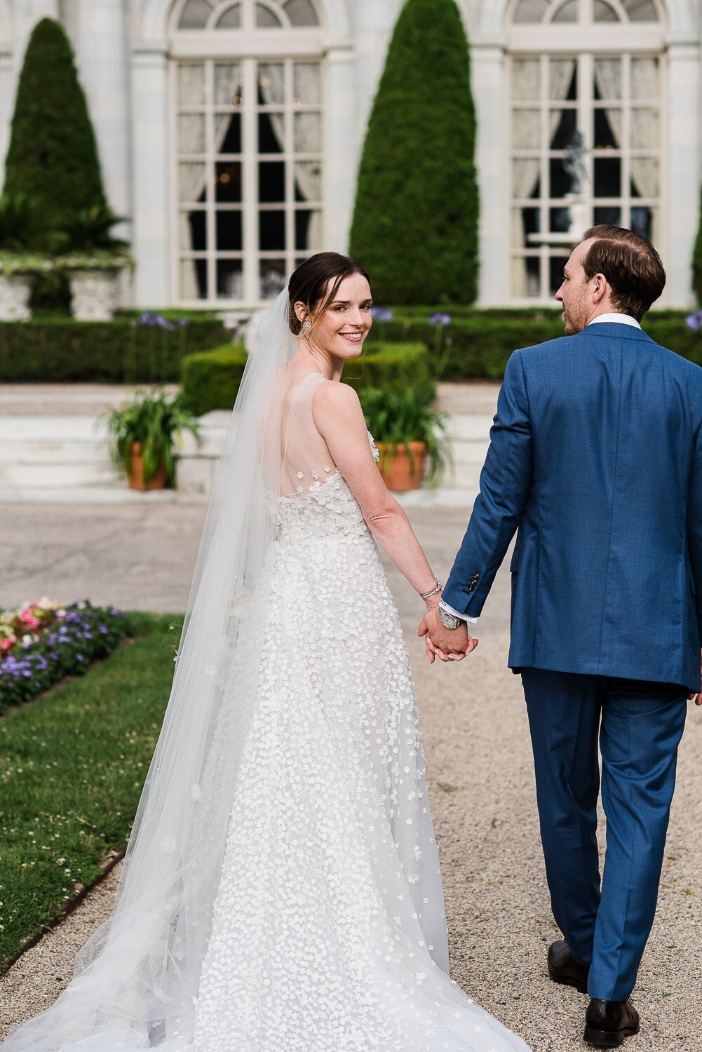 couple walking from behind bride looks back