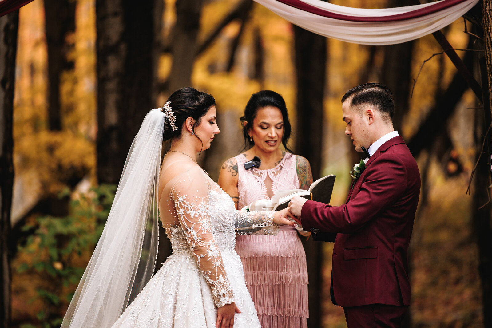Groom places ring on his brides finger during their wedding ceremony