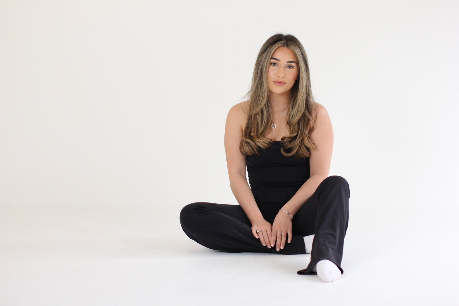 Smiling picture of a young lady working on her laptop at a brand photoshoot