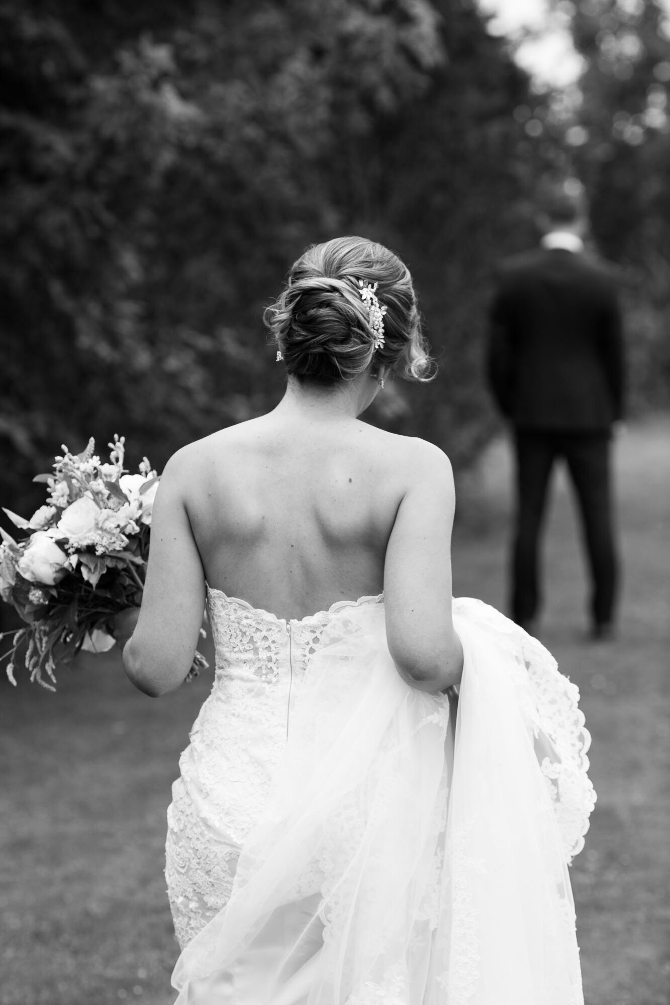 Bride walking with her bouquet and wedding dress in arms to greet her husband during their first look at Pondvalley Manor St Thomas.