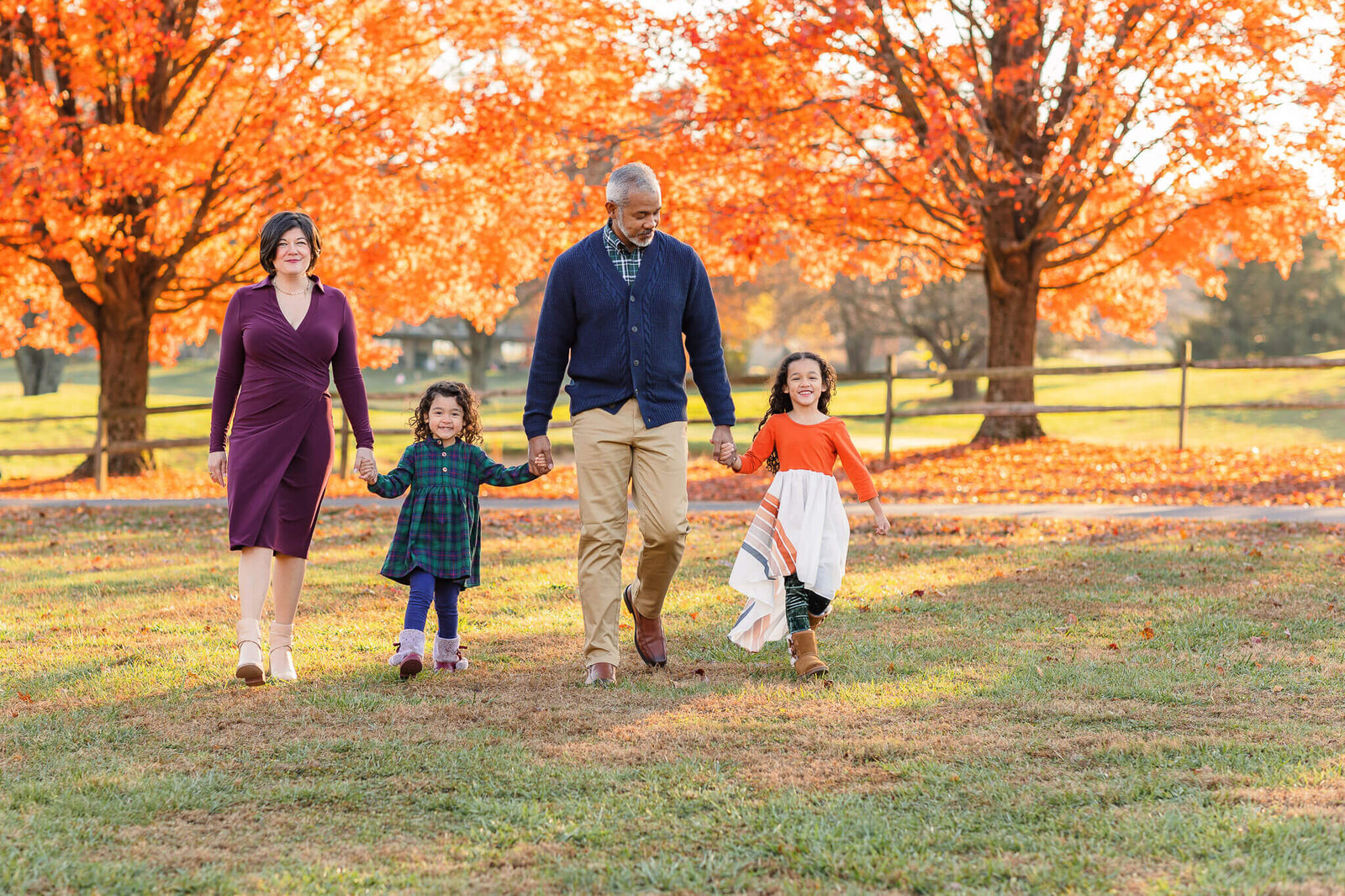 A family of four walking hand in hand at Burke Lake Park.