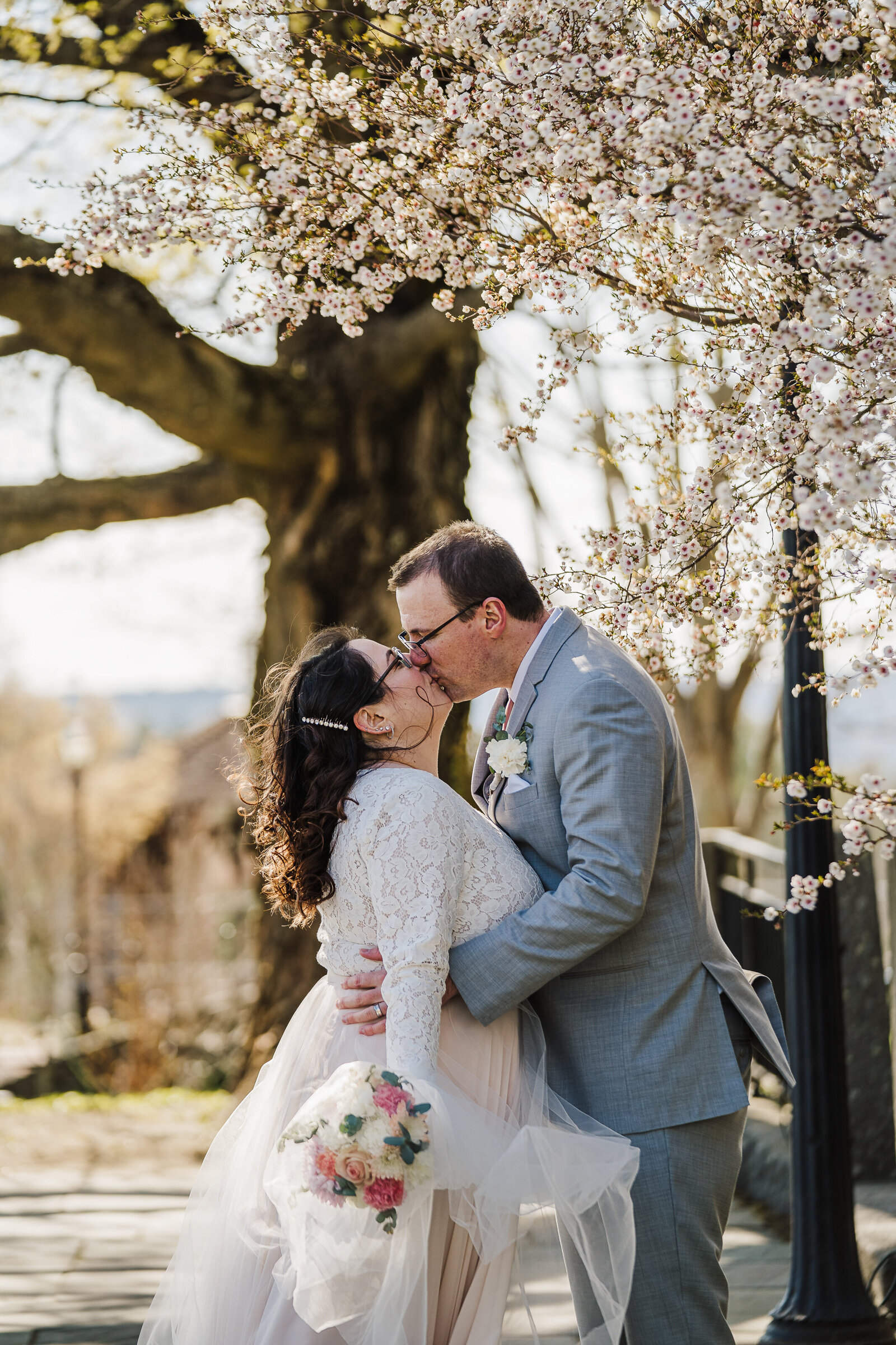 couple kisses under spring blossoms