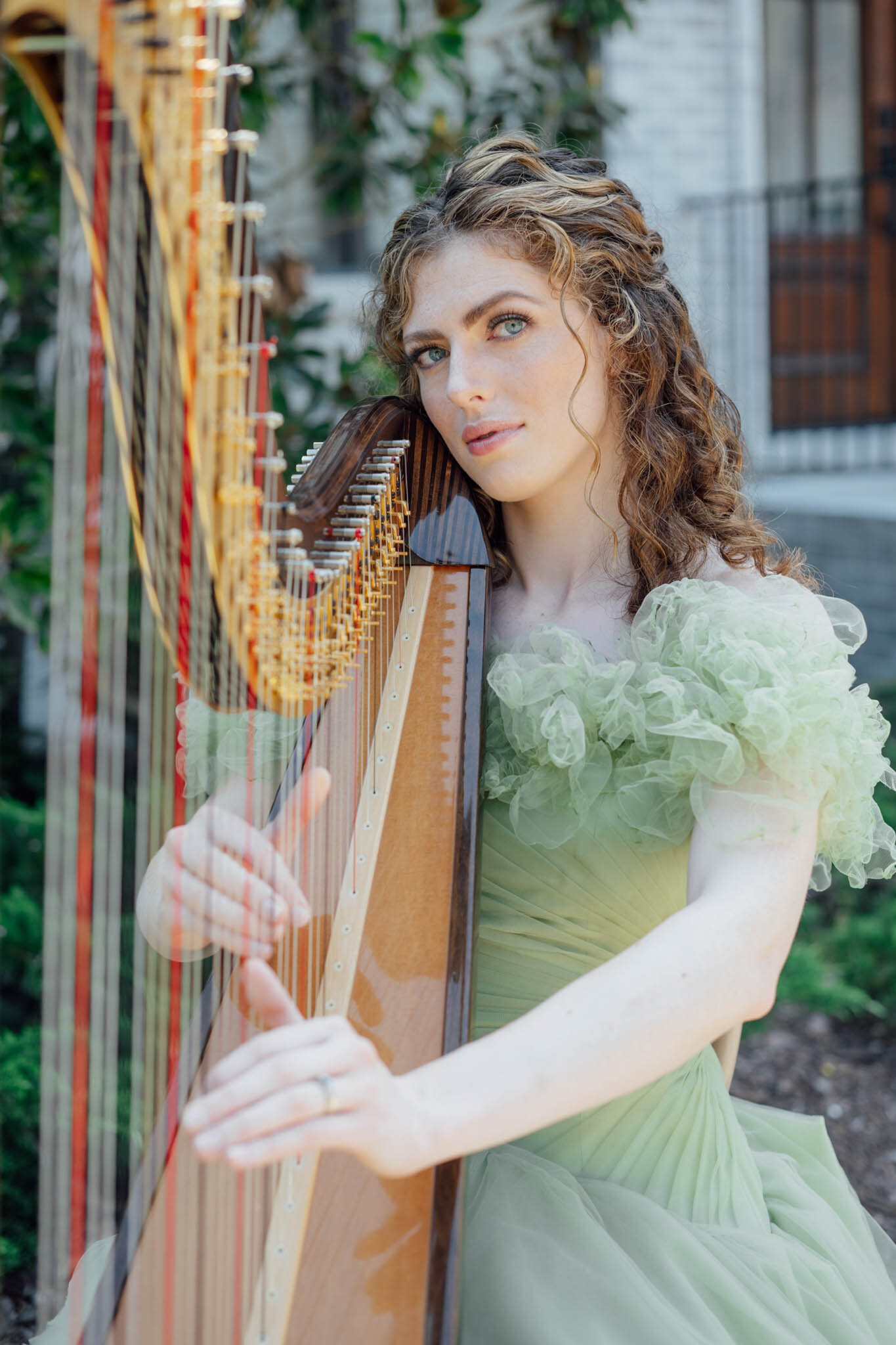 Woman in a green dress playing a harp