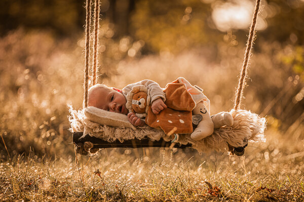 Een newborn fotoshoot in de natuur, omringt door de ouders en trouwe hond
