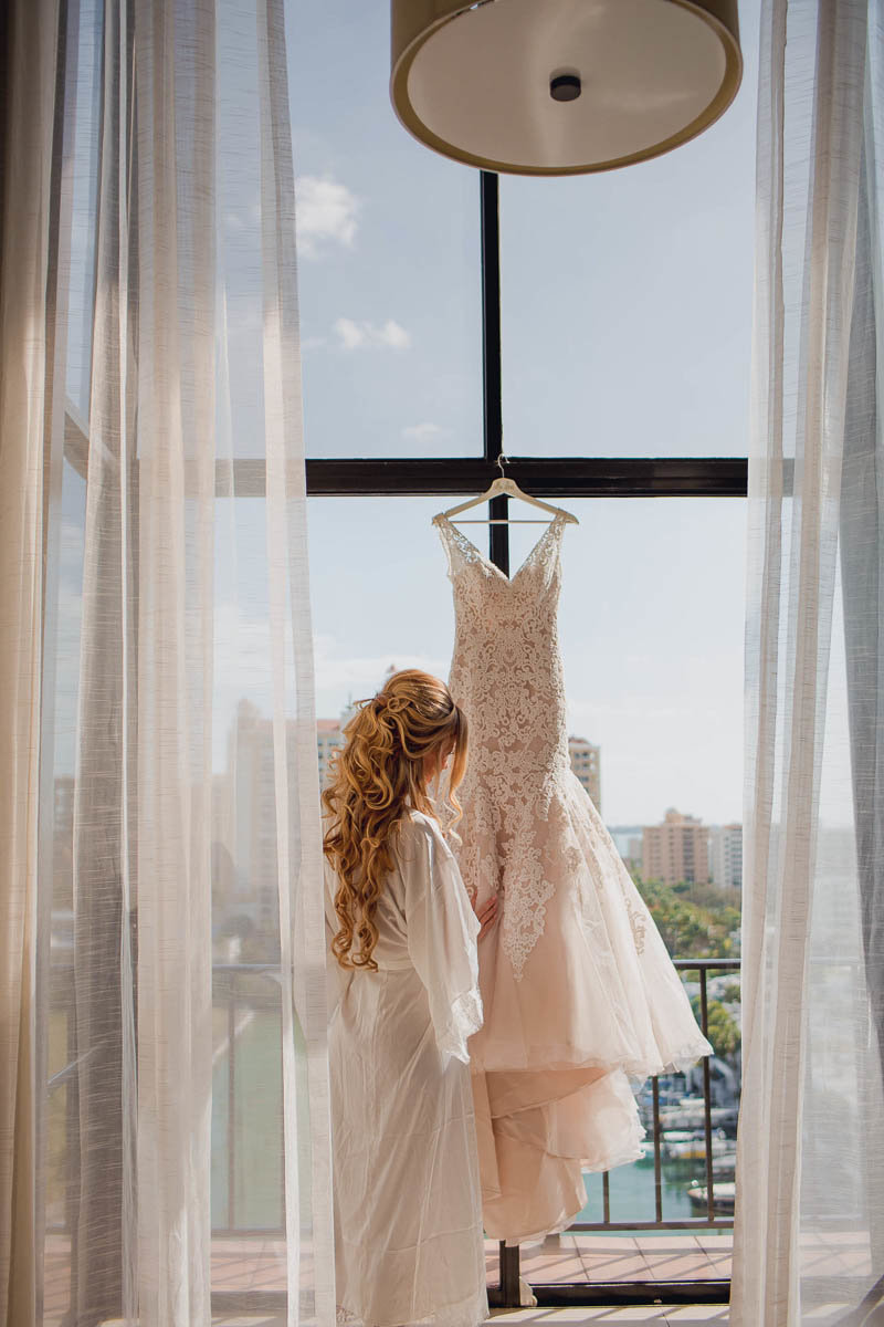 Bride reaches for dress, Destination wedding, Hyatt Regency, Sarasota, Florida