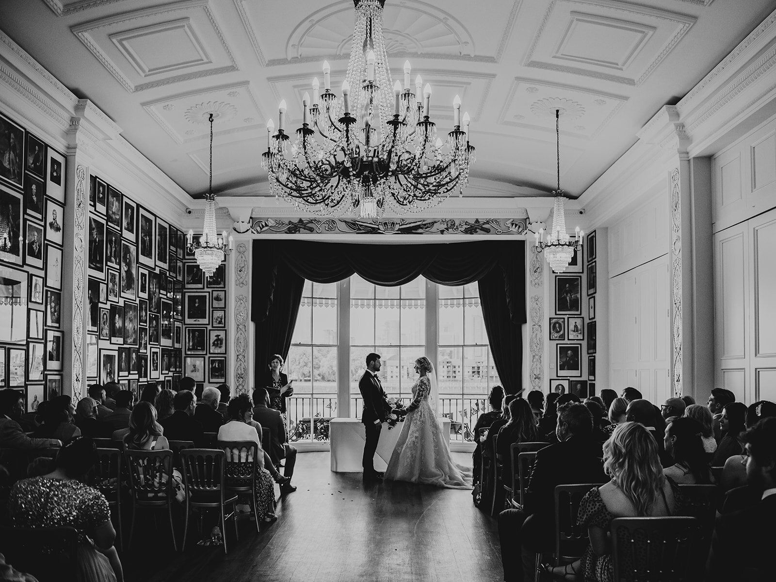 Bride and groom exchanging vows at their wedding at the Trafalgar Tavern in London, in black and white.