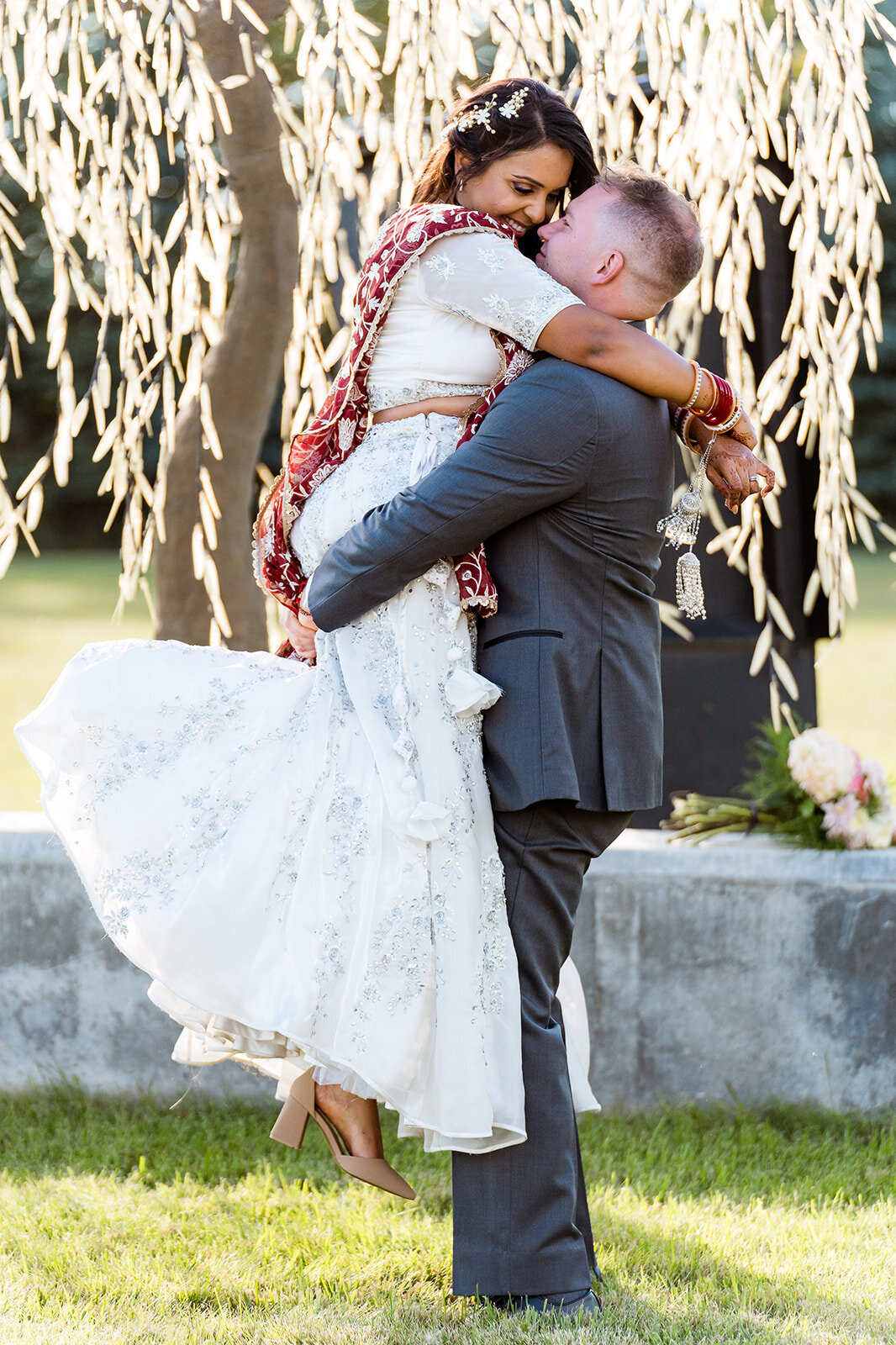 Groom picking up bride and having a cute and intimate moment   Tangled Roots