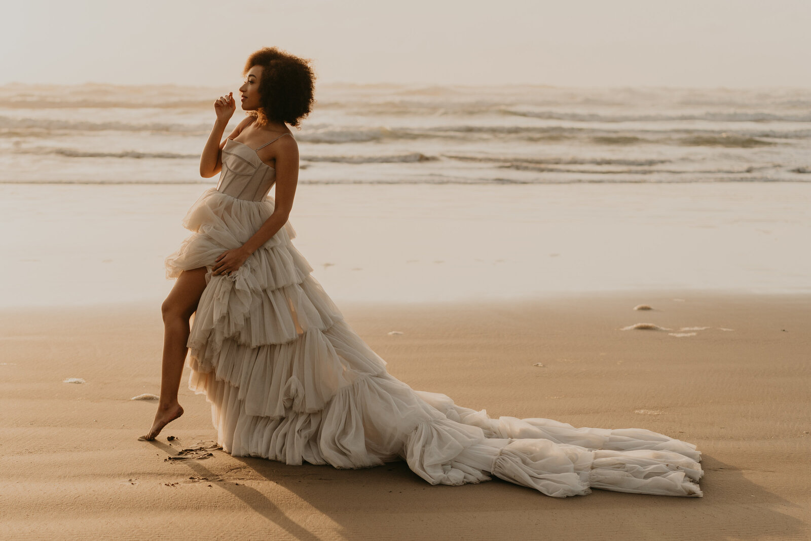 A bride posing on the beach.